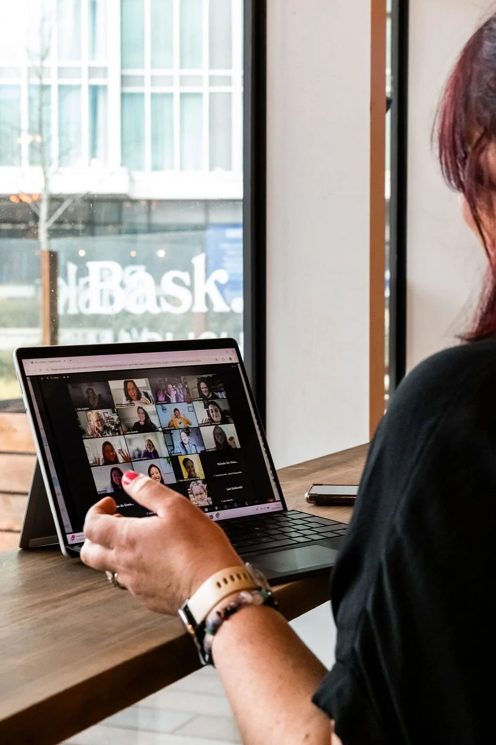 Karen is facing a laptop with faces in a Zoom call, reminiscent of a Do Crew session.