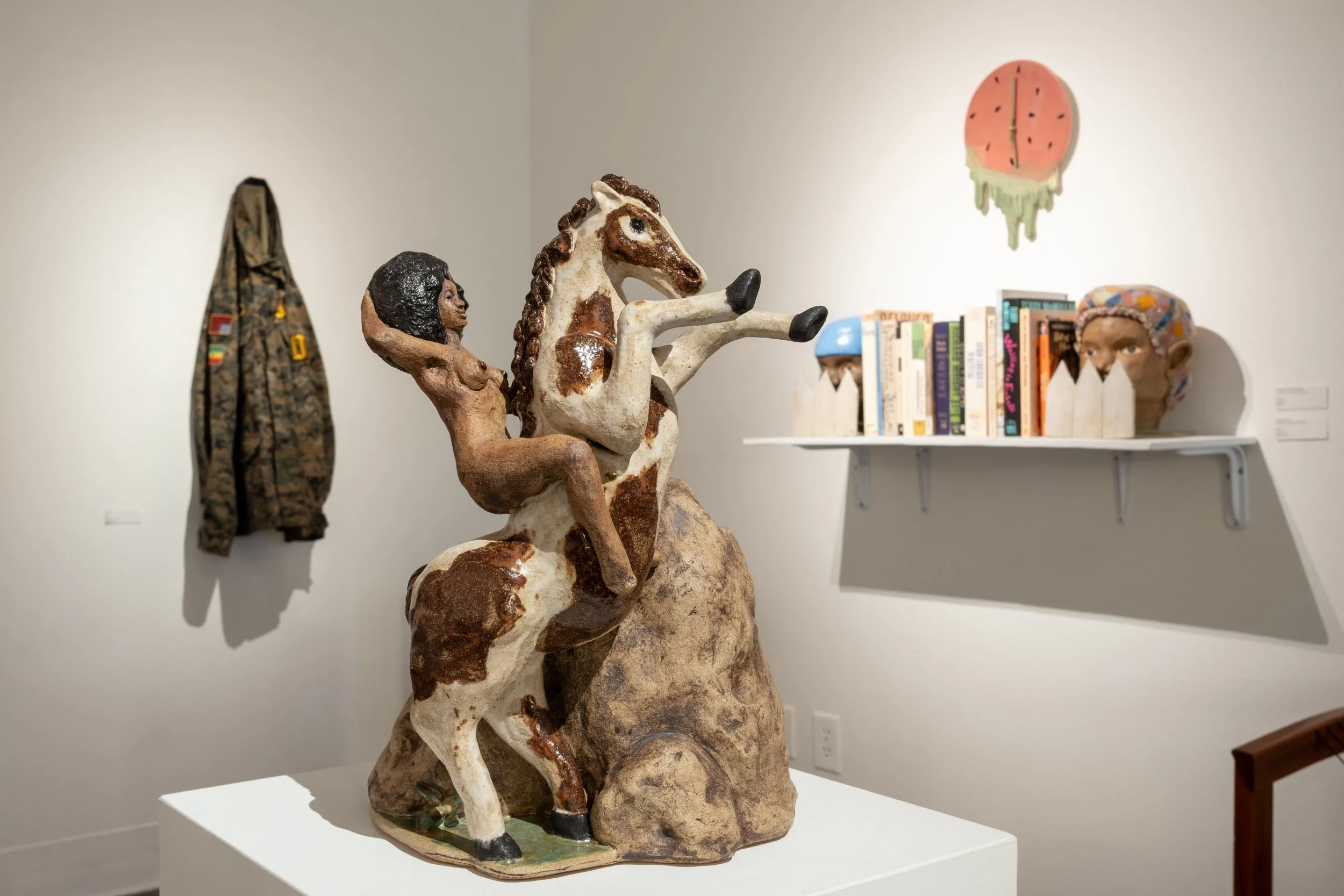 "Chief" by Young, (front) "Price of Freedom," "Neighbors," and "Watermelon Clock" by Christina Joseph