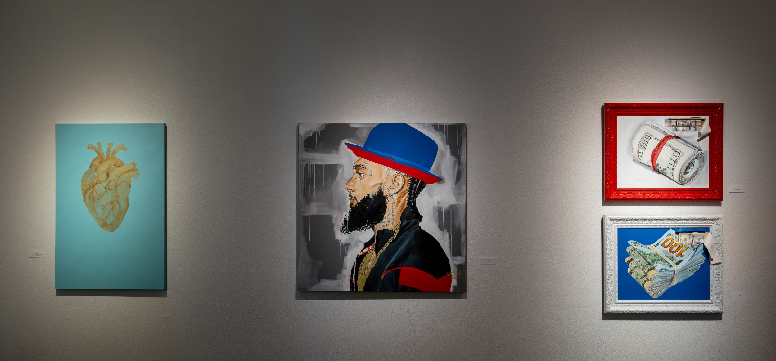 (L to R) "King's Heart" Painting by Malachi Sparrow Williams; "King Nipsey," "Bank Roll," "Stacks" Paintings by Courtney Yard$ Haywood 