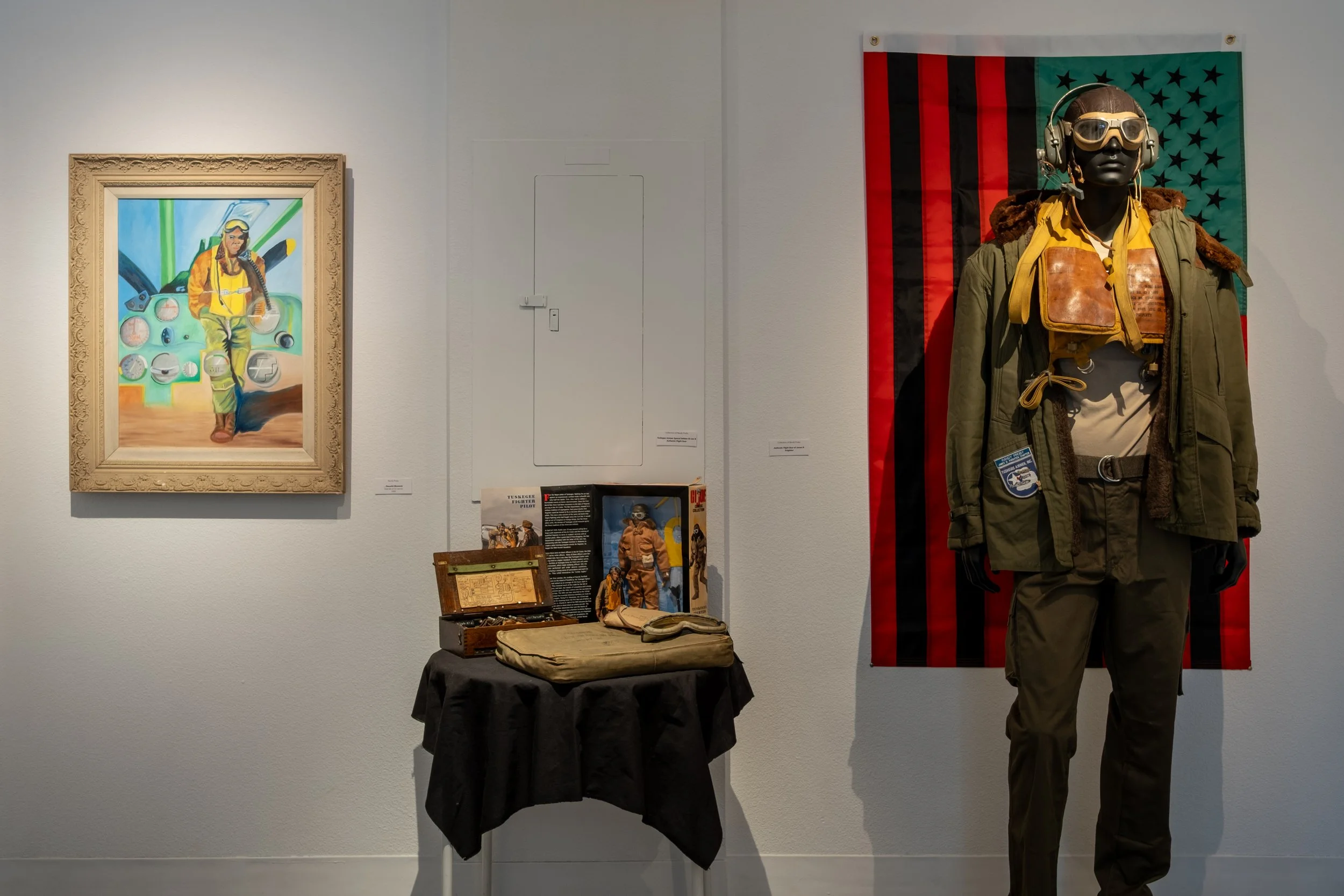 (L) "...Peaceful Moments" by Randy Proby, 1998 ; "Tuskegee Airmen G.I. Joe & Authentic Flight Gear" Courtesy the Collection of Randy Proby