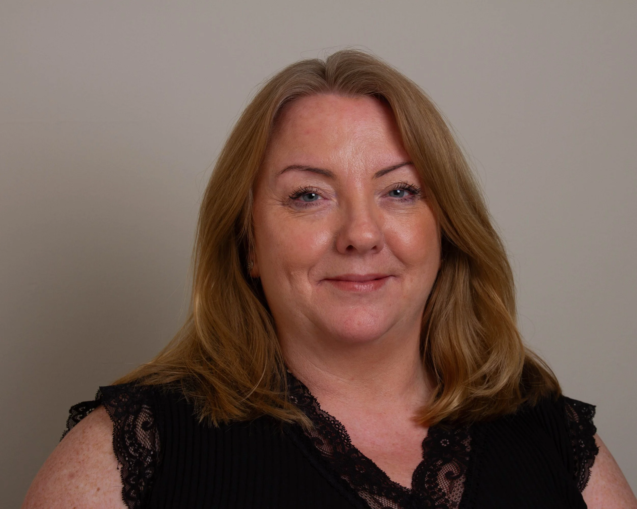Liz Lavin smiling against a beige background