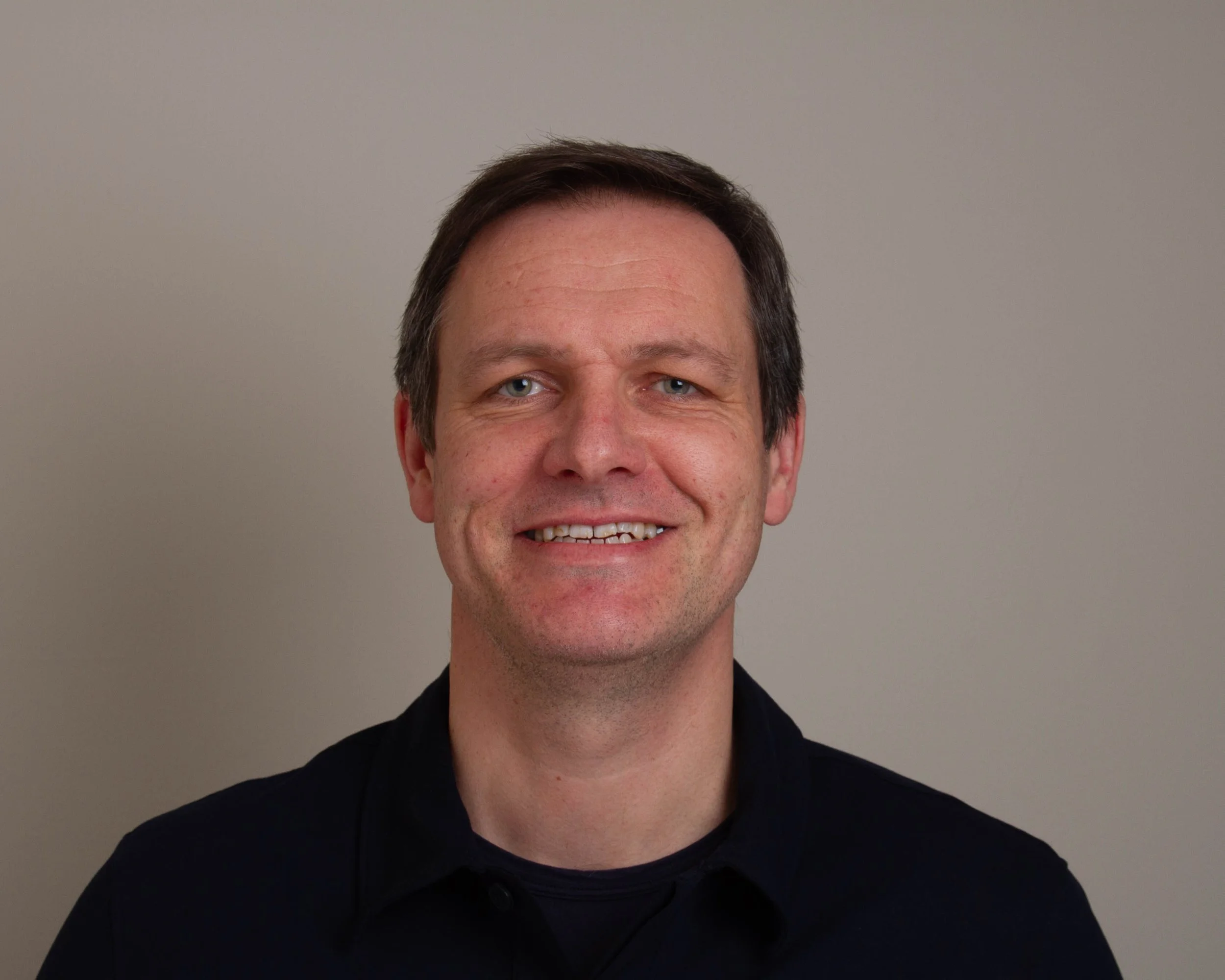 Dan McKeown, wearing a dark shirt against a plain background.