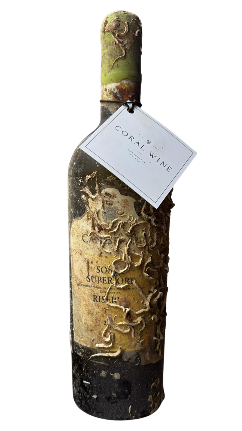 A wine bottle wrapped in vine roots with a white tag that reads 'Coral Wine'.