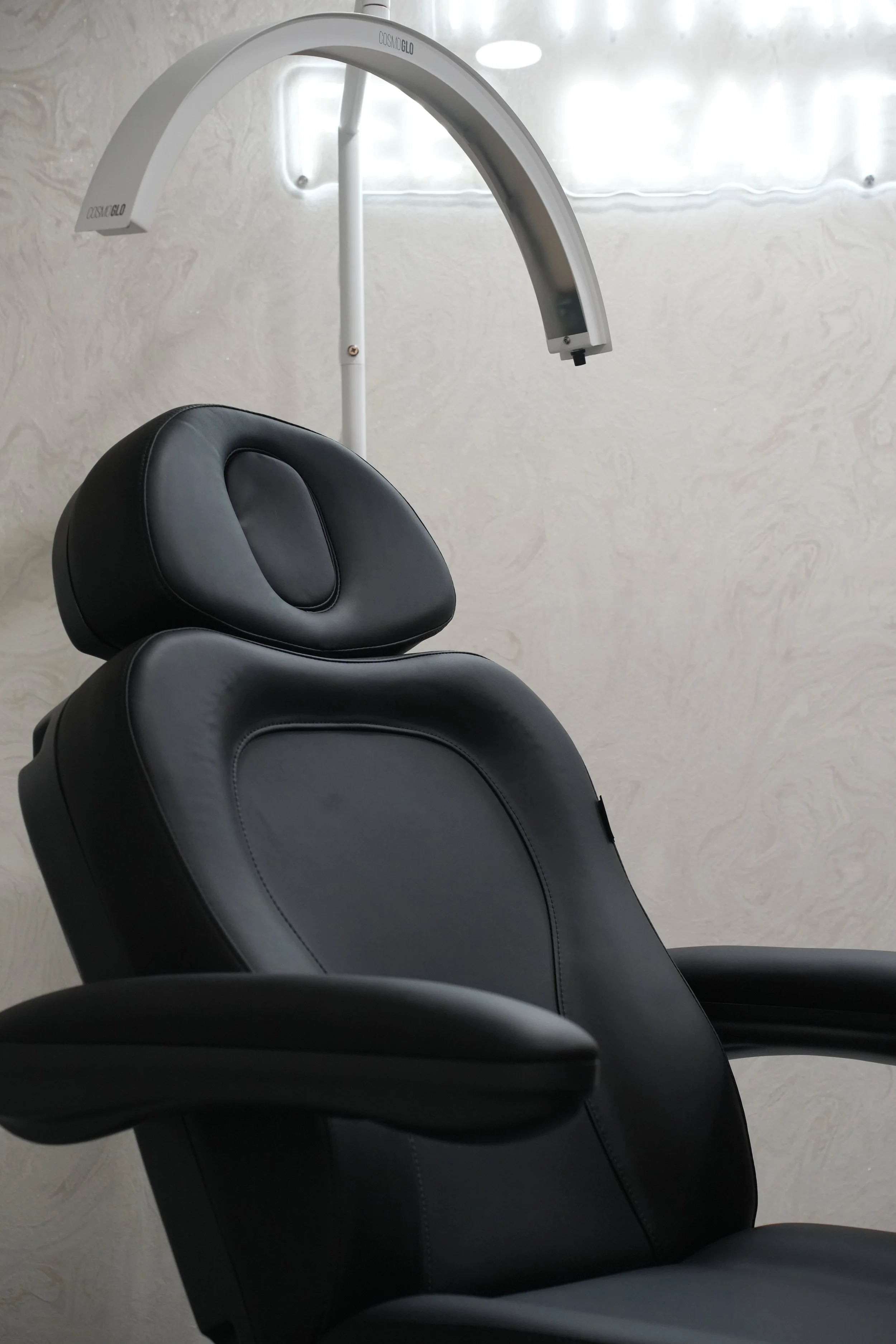 Dental chair with headrest and overhead curing light in a dental clinic easel.