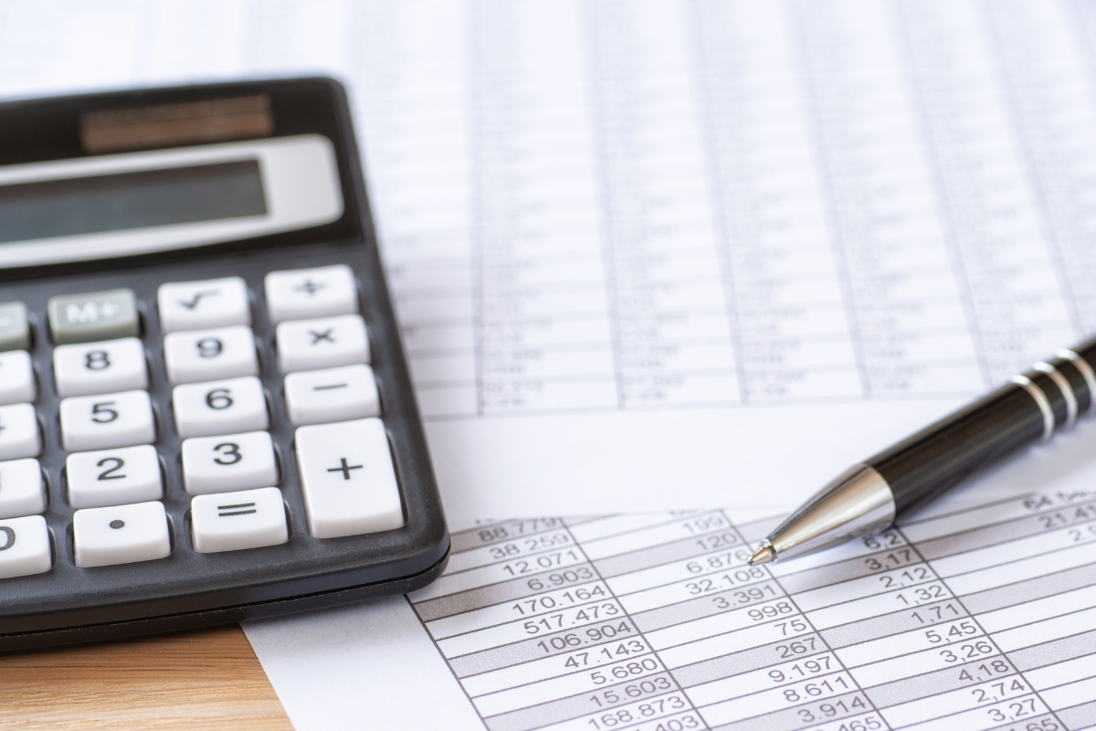 Calculator and pen on financial spreadsheets.
