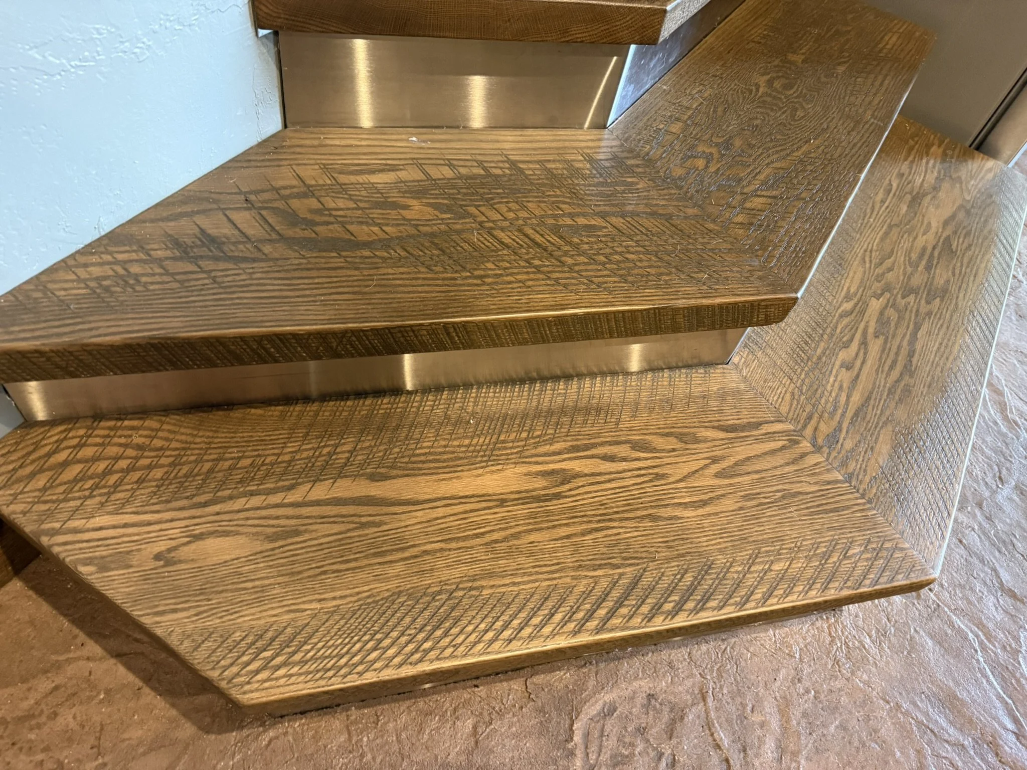 Rustic oak stair treads with original saw marks, stainless steel-clad risers