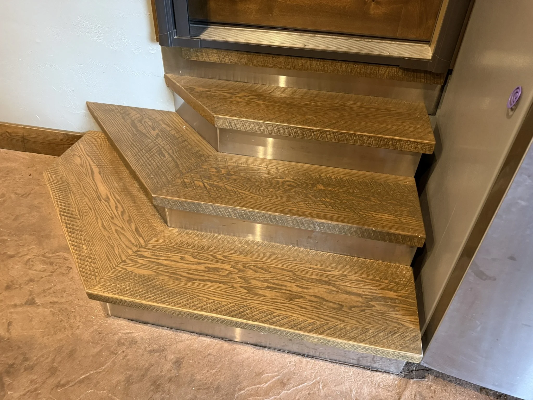 Rustic oak stair treads with original saw marks, stainless steel-clad risers