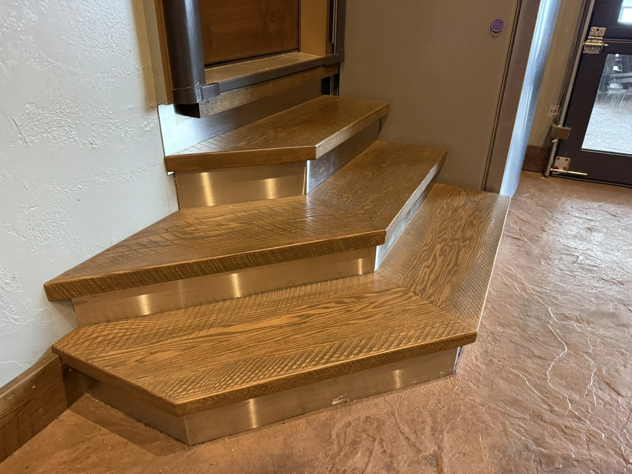 Rustic oak stair treads with original saw marks, stainless steel-clad risers