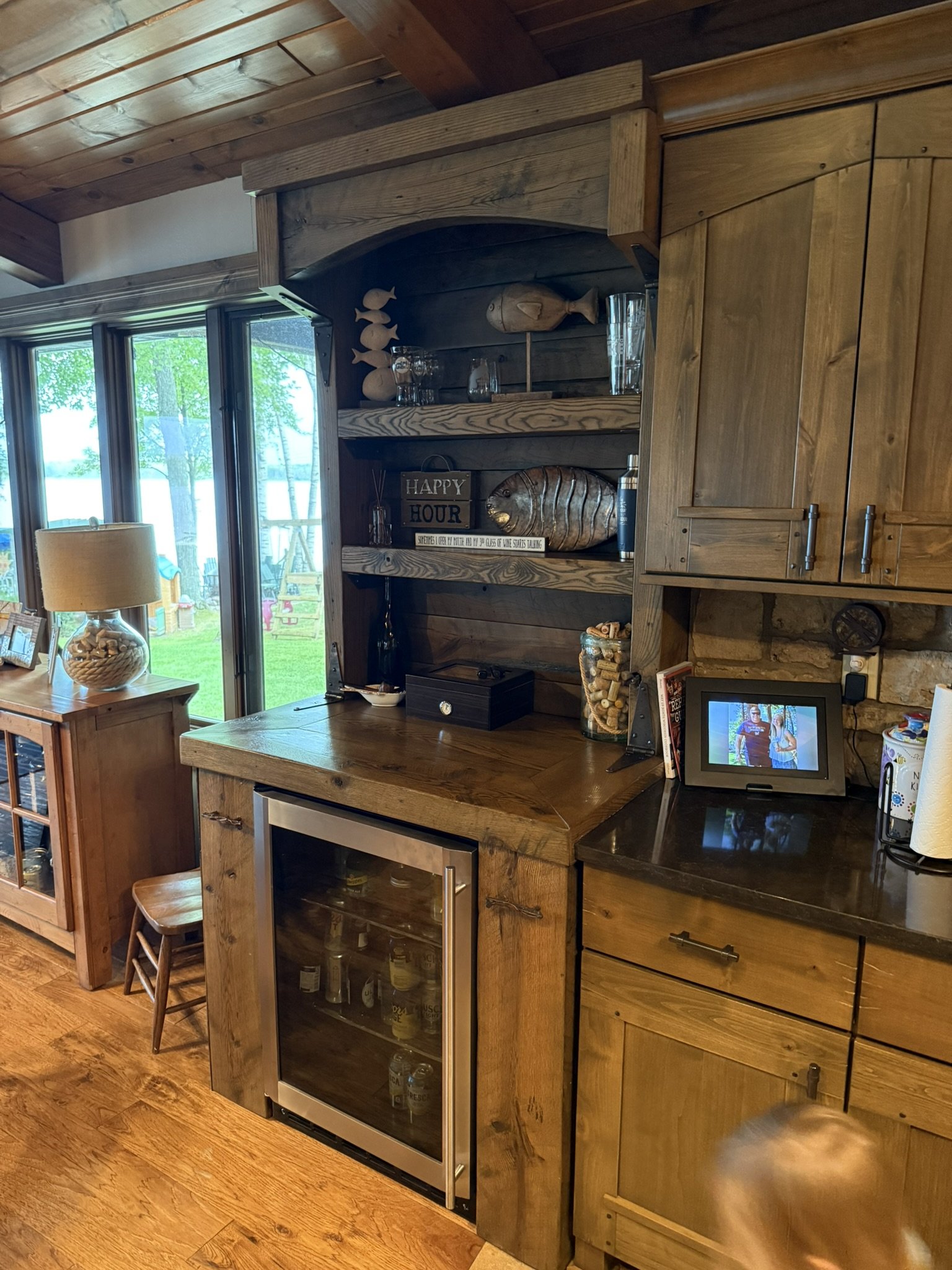 Rustic pine and oak dry bar with mini fridge compartment, shelves, and hidden side cabinets