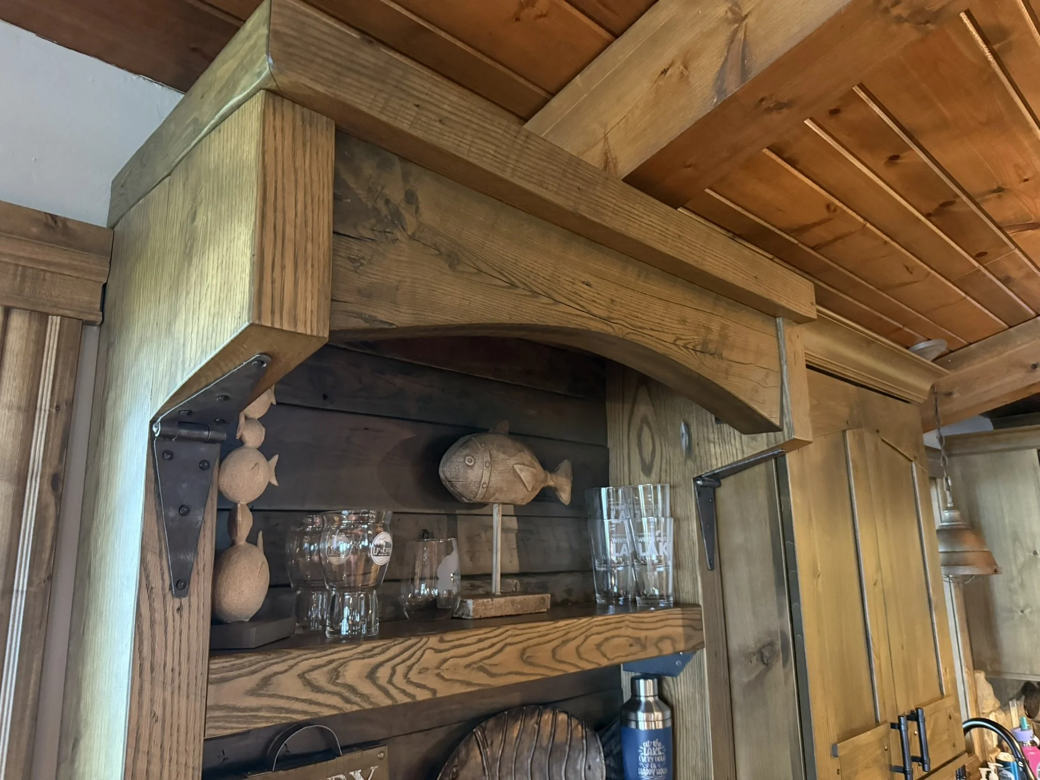 Rustic pine and oak dry bar with mini fridge compartment, shelves, and hidden side cabinets