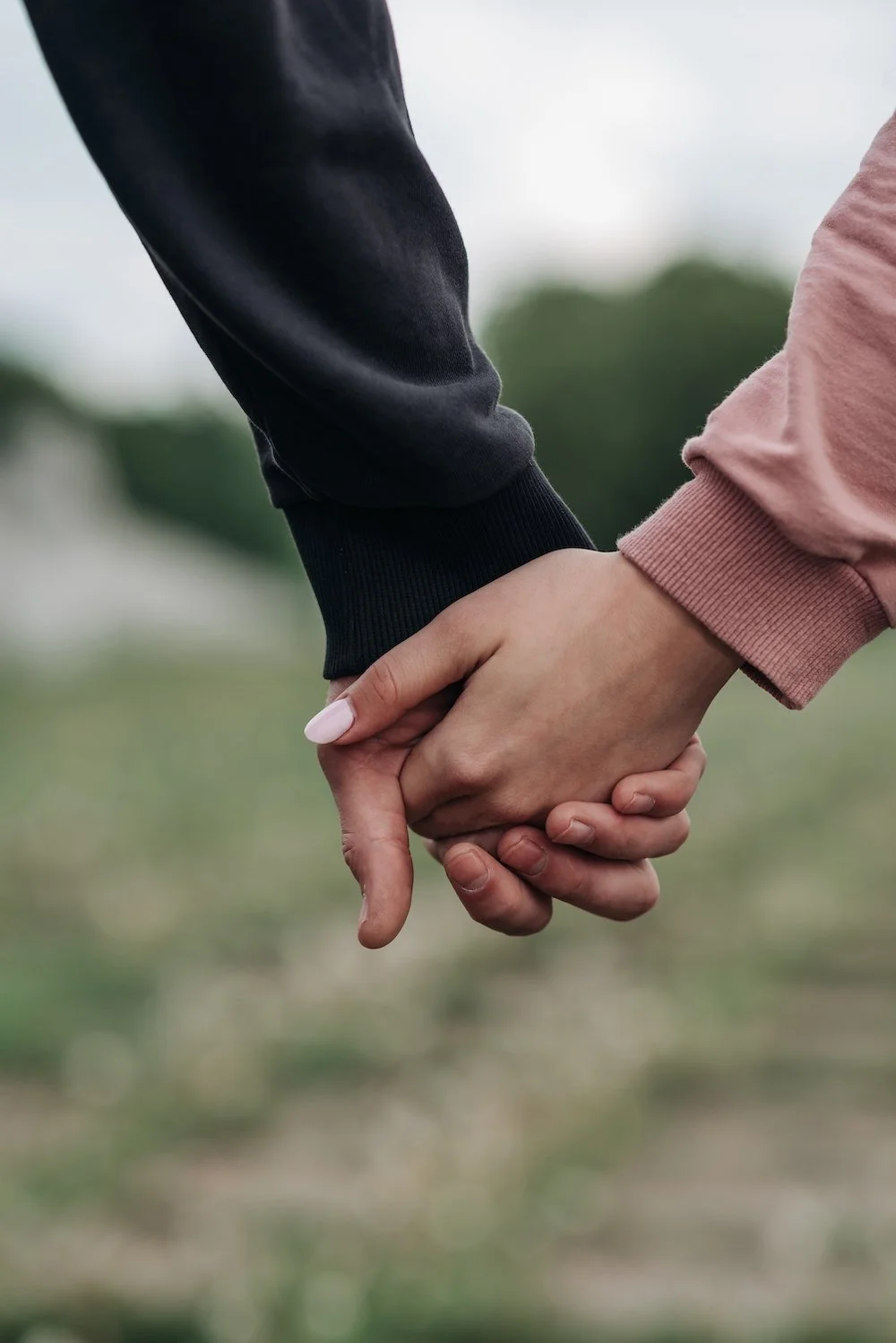 Close-up of a couple holding hands, representing connection and support