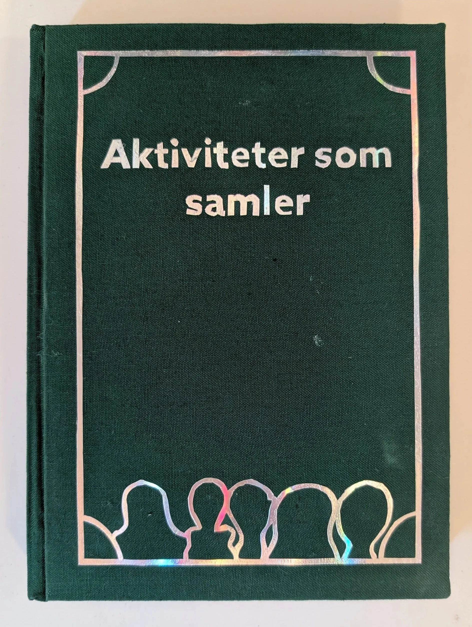 Green hardcover book titled 'Aktiviteter som samler' with holographic border design.