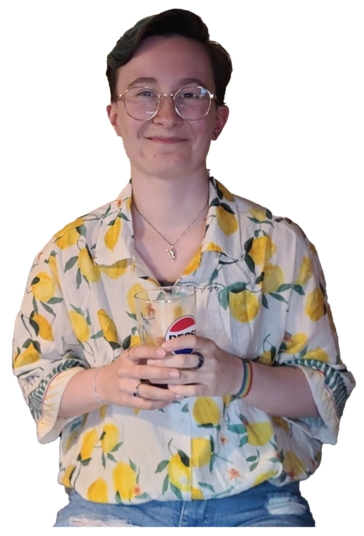 Me! A person with short dark hair wearing glasses, a lemon-patterned shirt, and a rainbow bracelet, holding a glass of soda and smiling.