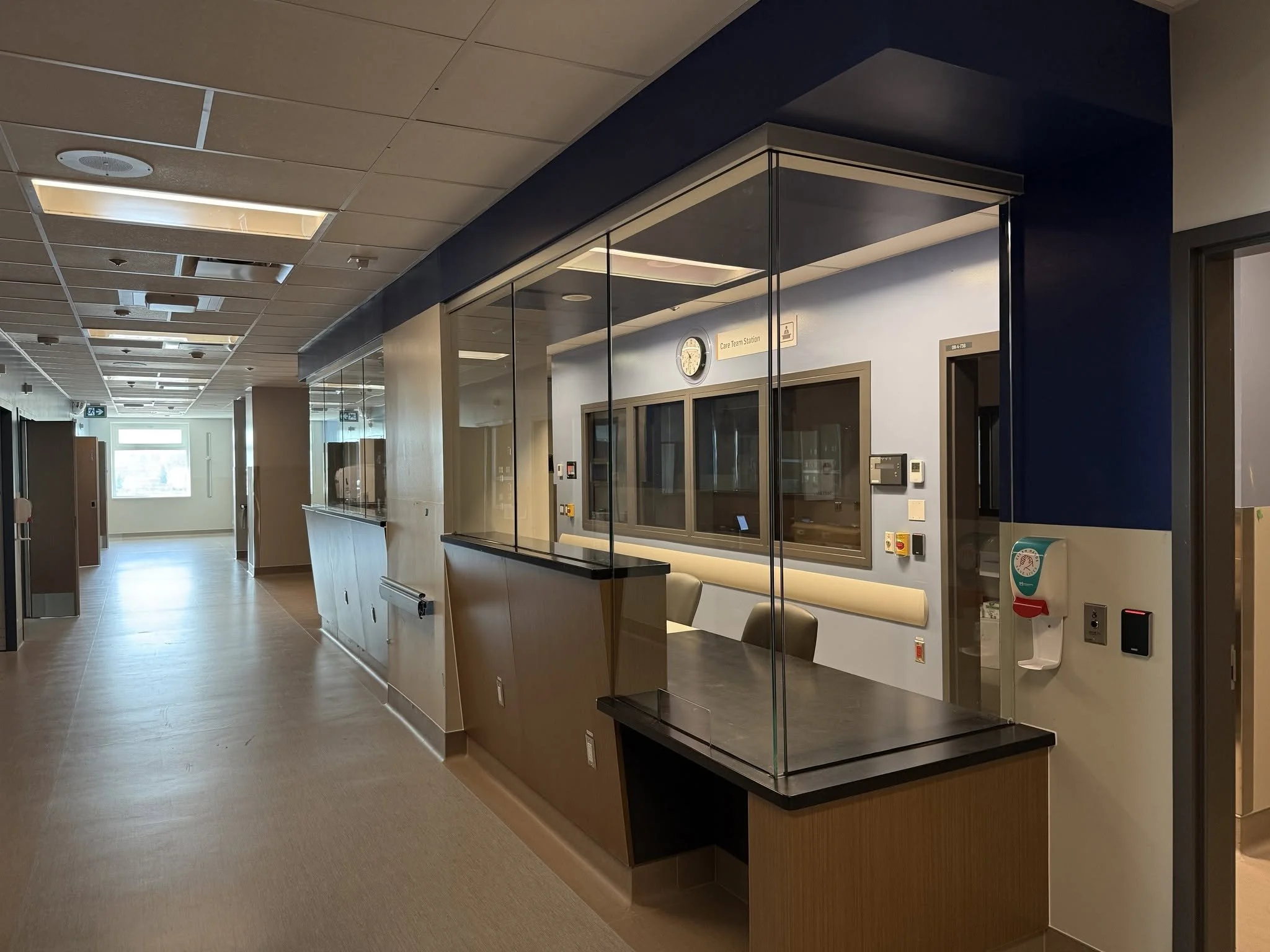 Side view of a glass-enclosed reception counter with a lower counter section.