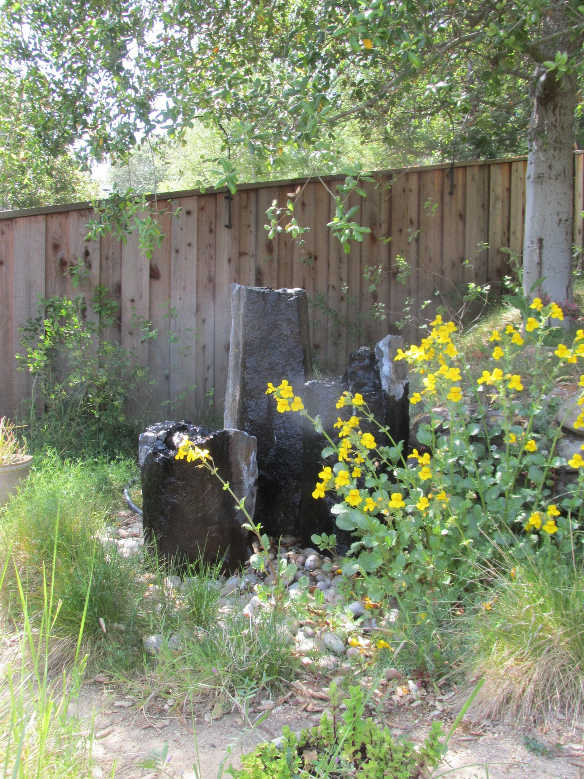 A grouping of columnar basalt forms a pondless fountain - water is a key habitat feature in this wildlife garden.