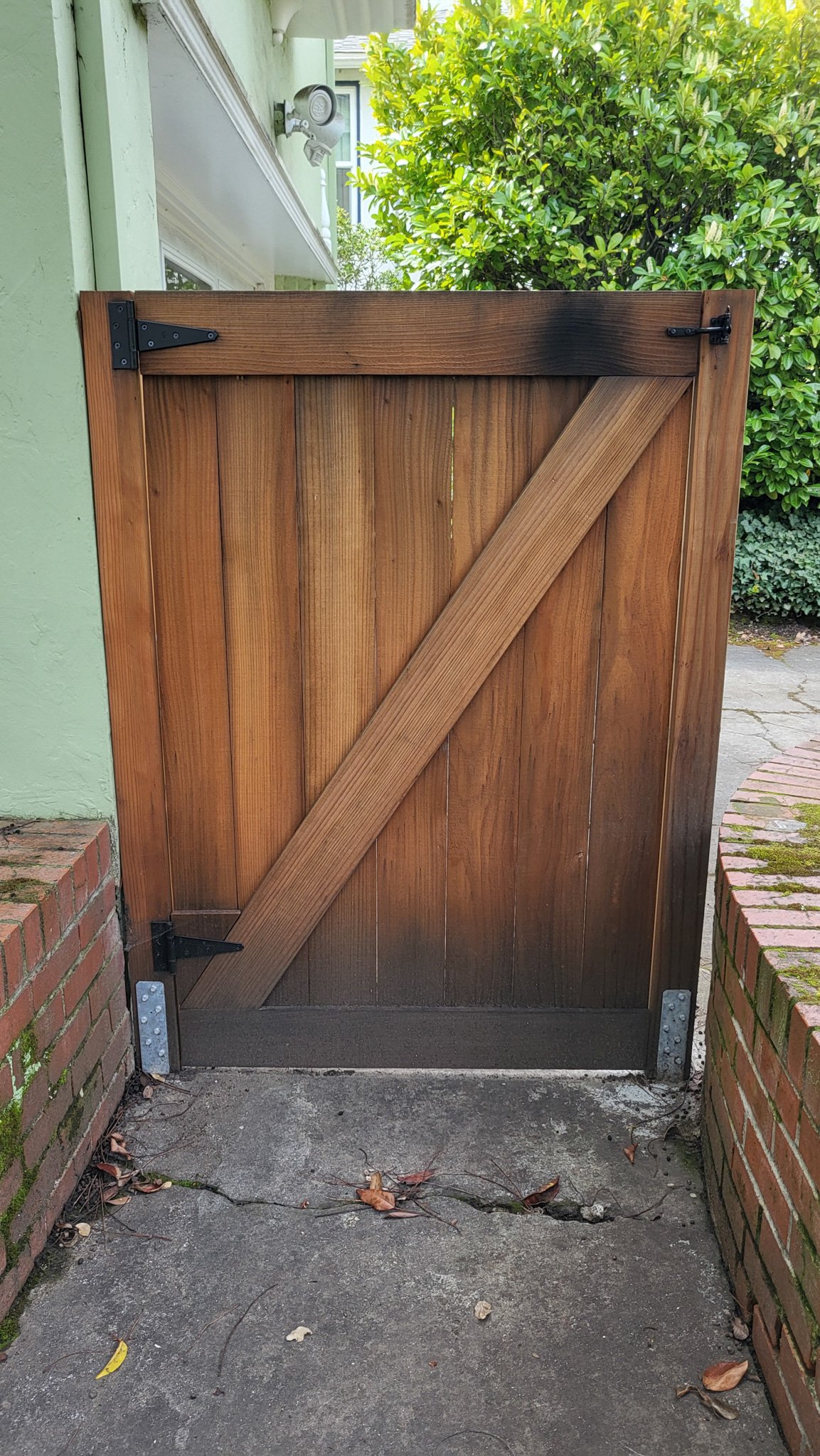 A wood gate with a diagonal cross brace