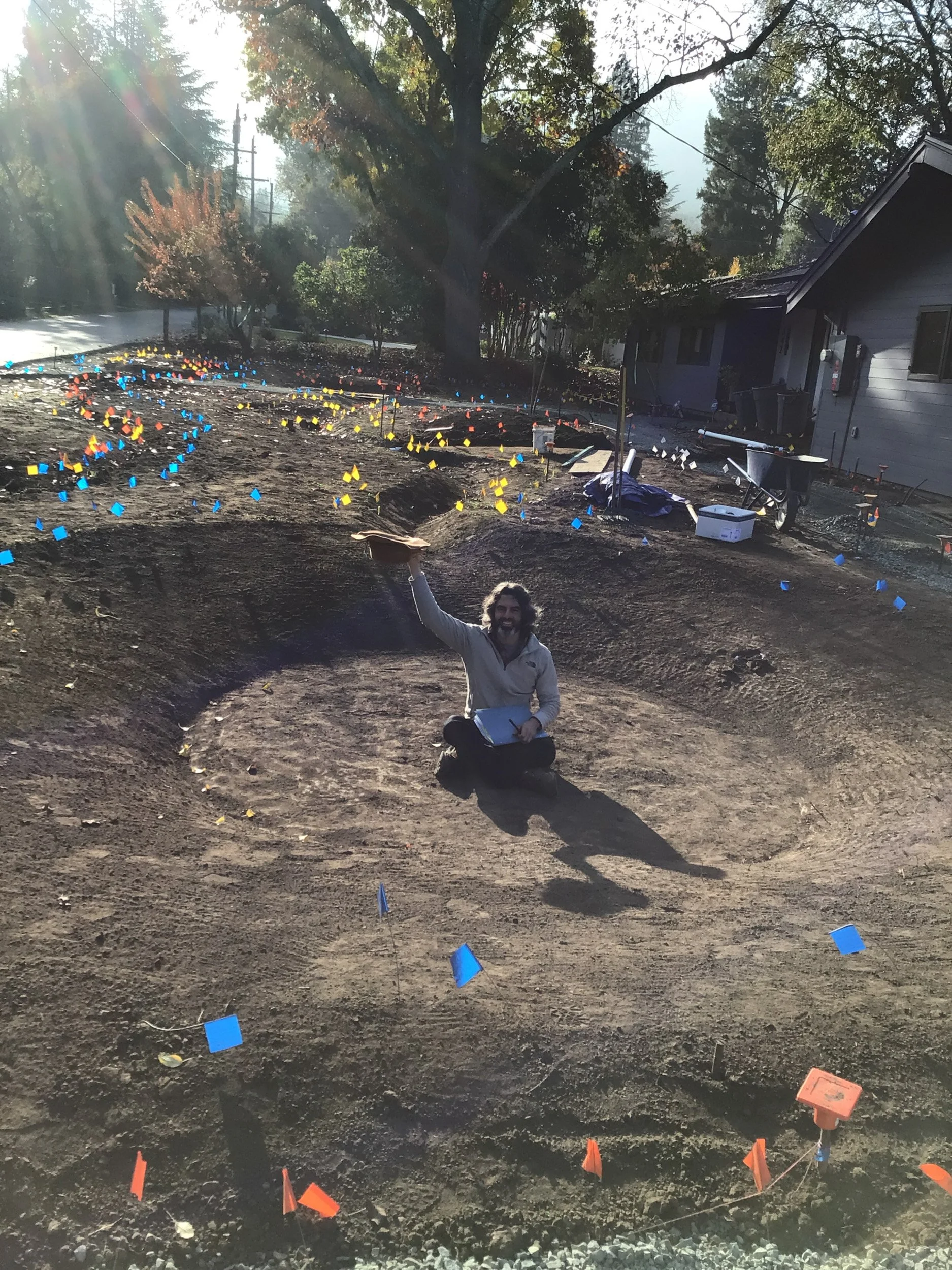 A planted bioswale to slow and sink water during a storm - installation photo of sculpted topography under construction.