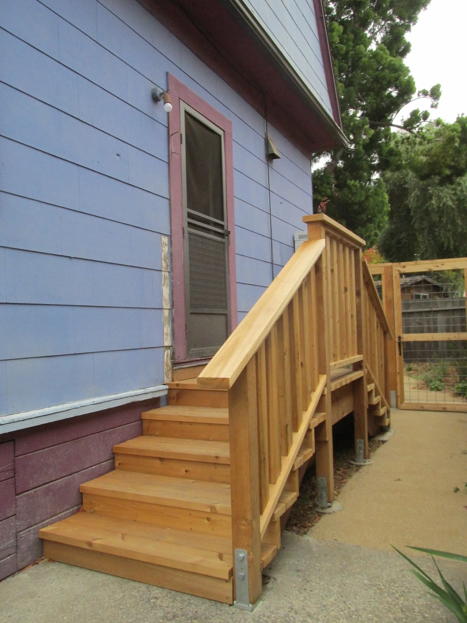 A wood landing and stairway with a wood railing