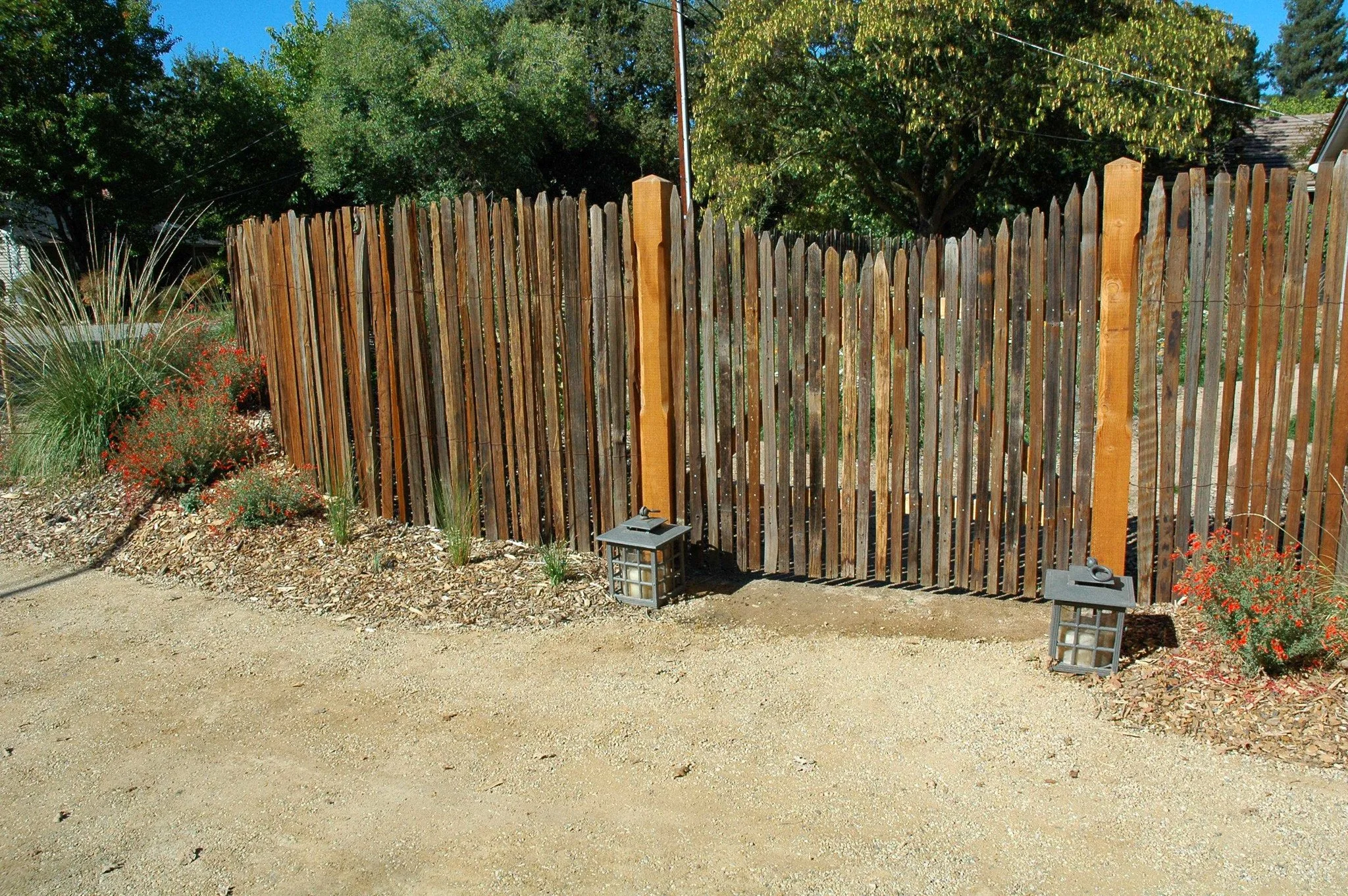 Vertical slats wood fence in front of tan dg patio