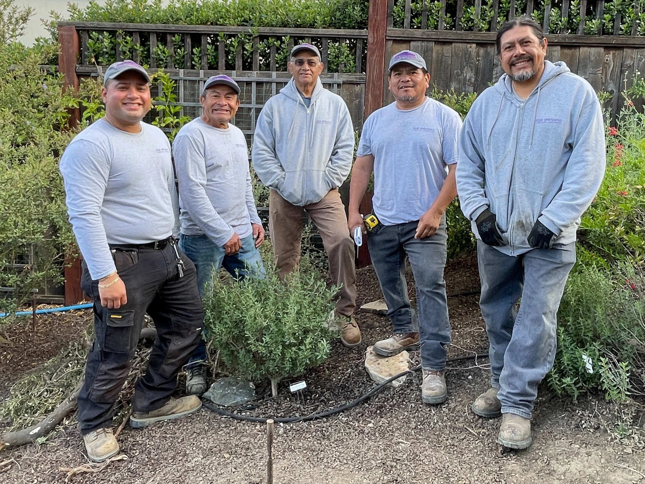 Landscape installation team stands outside near california native plants