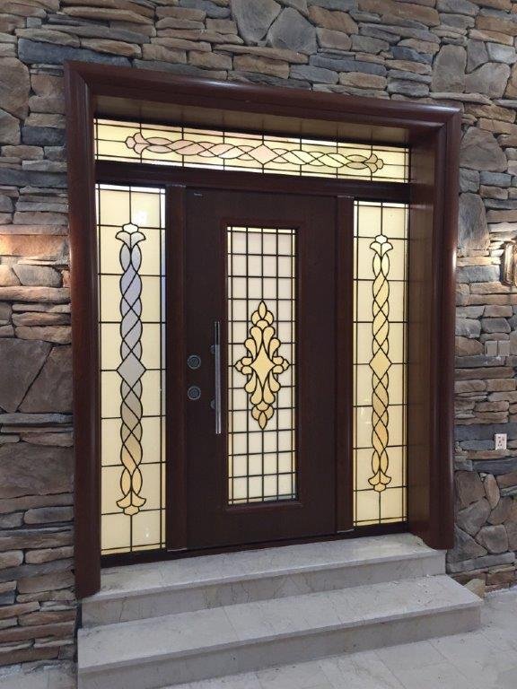 Front door with decorative stained glass and stone wall