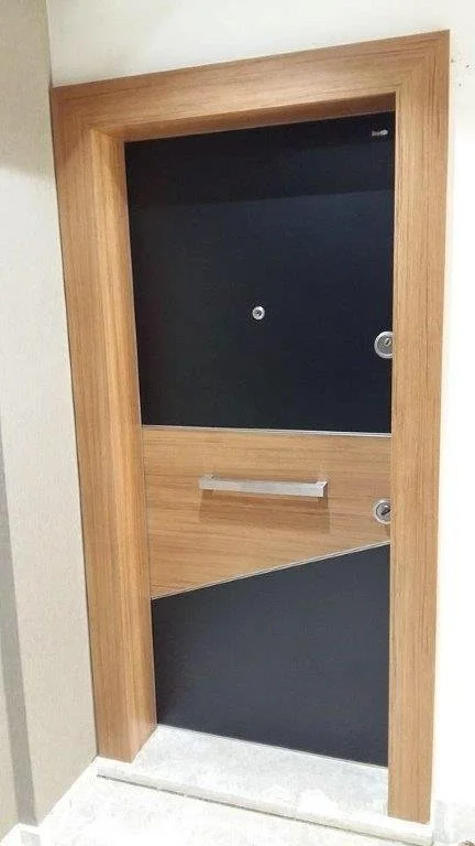 A door with a wooden frame and black panels, featuring a small peephole, a door handle, and a mail slot.