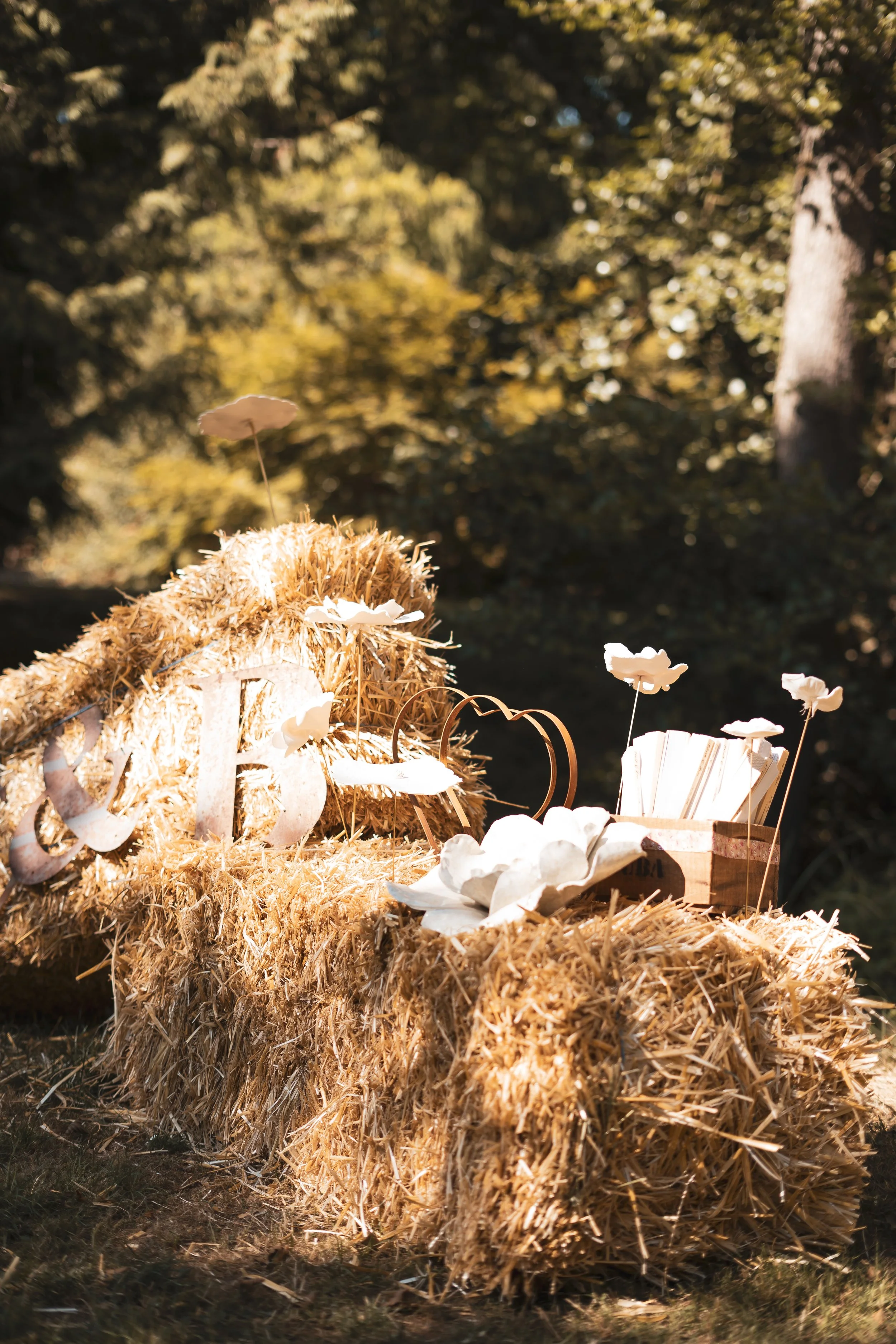 Ambiance bohème chic pour ce décor de cérémonie en extérieur. Les bottes de paille sont mises en valeur par des pièces uniques en porcelaine et grès. Un équilibre parfait entre artisanat brut et raffinement pour un "slow wedding" épuré.