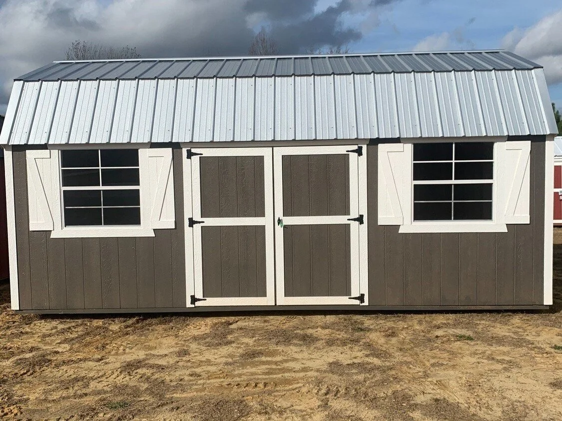 Wooden storage shed with gray walls, white trim, and a metal roof.
