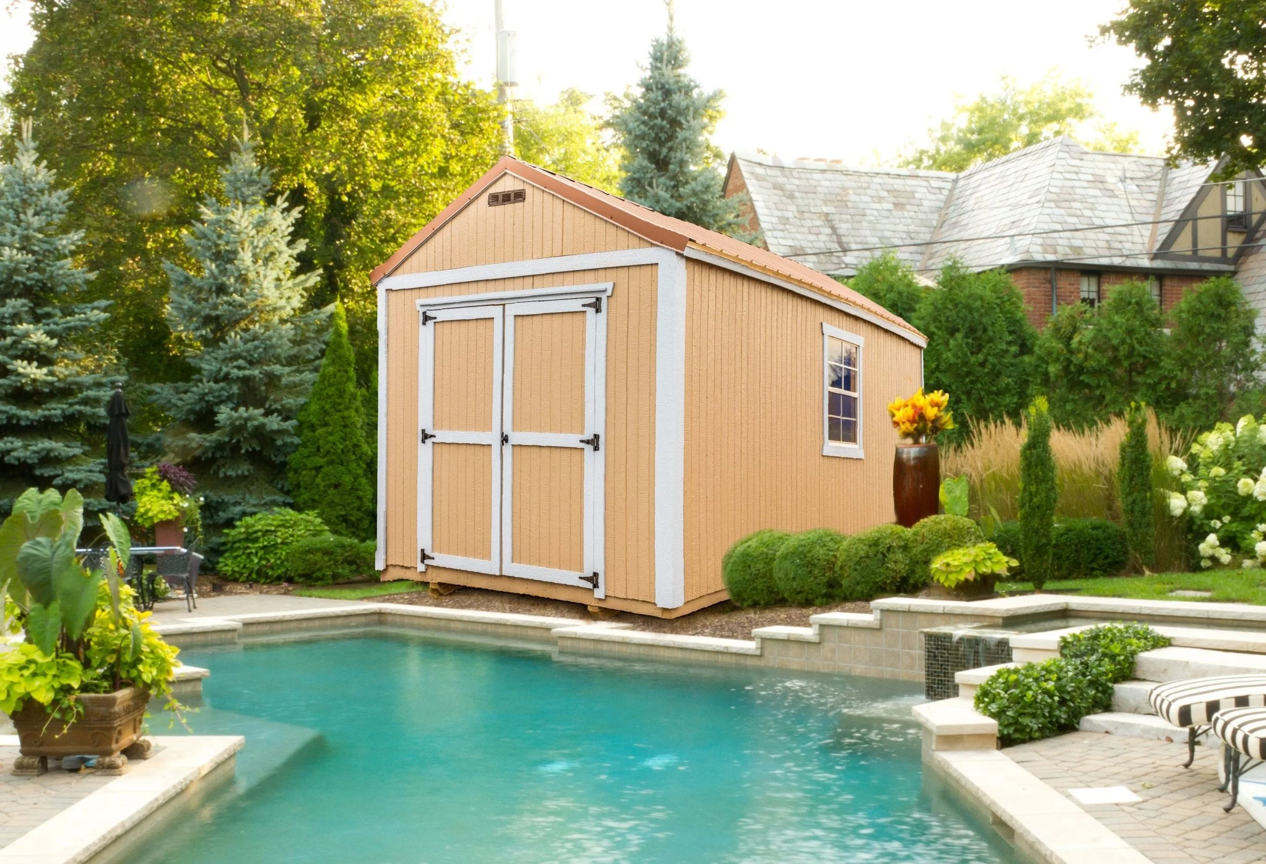 Backyard with a small wooden shed, swimming pool, patio furniture, greenery, and a house in the background.
