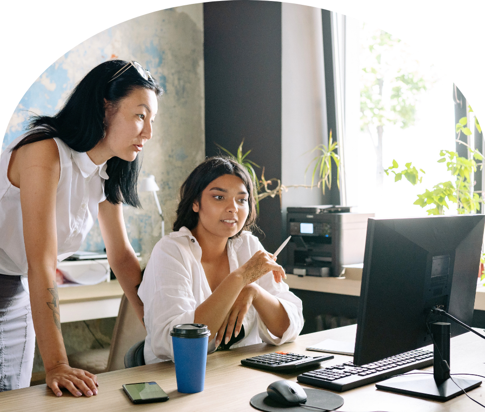 Two women work side by side at a desk — reflecting the collaborative, no-stake coaching relationship that defines leadership coaching for nonprofit, advocacy, and public service professionals.