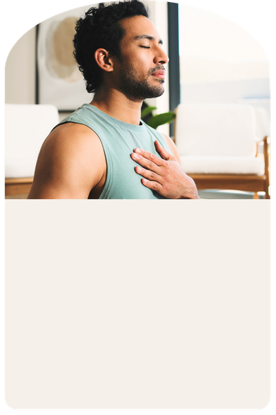 A man sits with eyes closed and hand on chest in a somatic therapy exercise, practicing body-based healing and nervous system regulation.