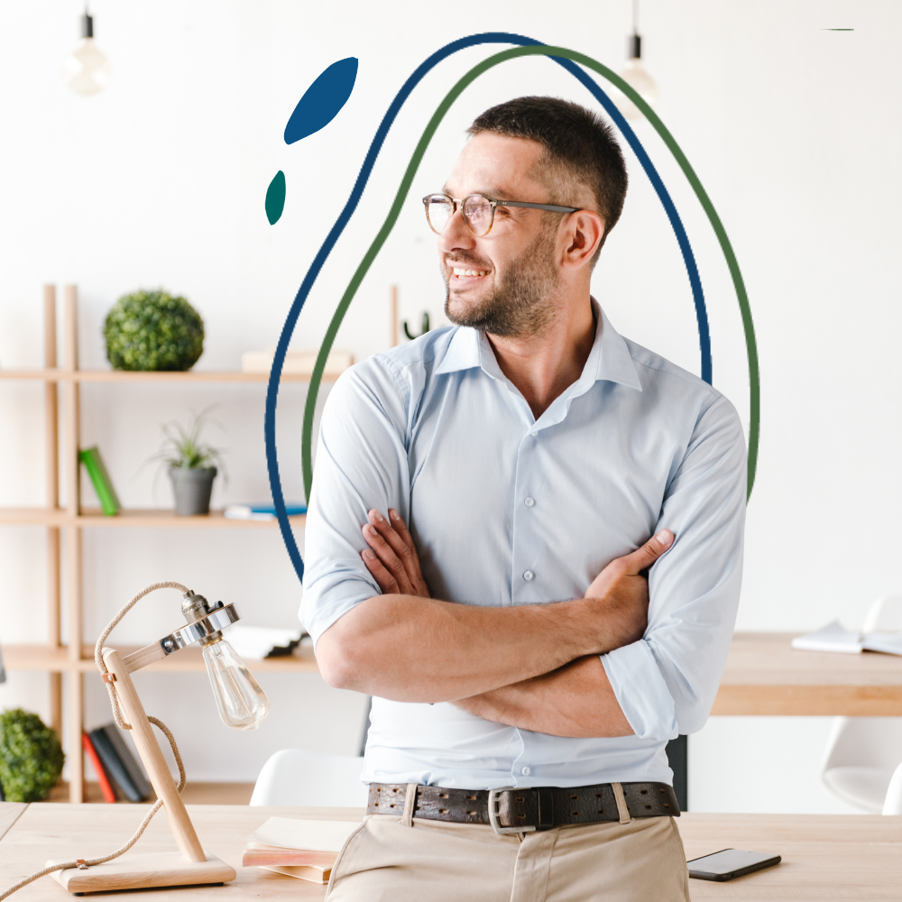 A confident professional stands with arms crossed in a bright workspace — representing the clarity and direction that comes from working with a leadership coach specializing in nonprofit, government, and social impact careers.