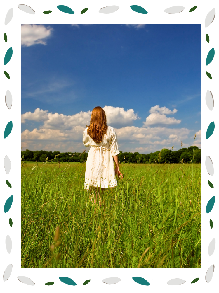 A woman stands alone in an open field, back to the camera — representing the burnout and emotional exhaustion that brings mission-driven professionals, caregivers, and those navigating aging parents to therapy in North Carolina.