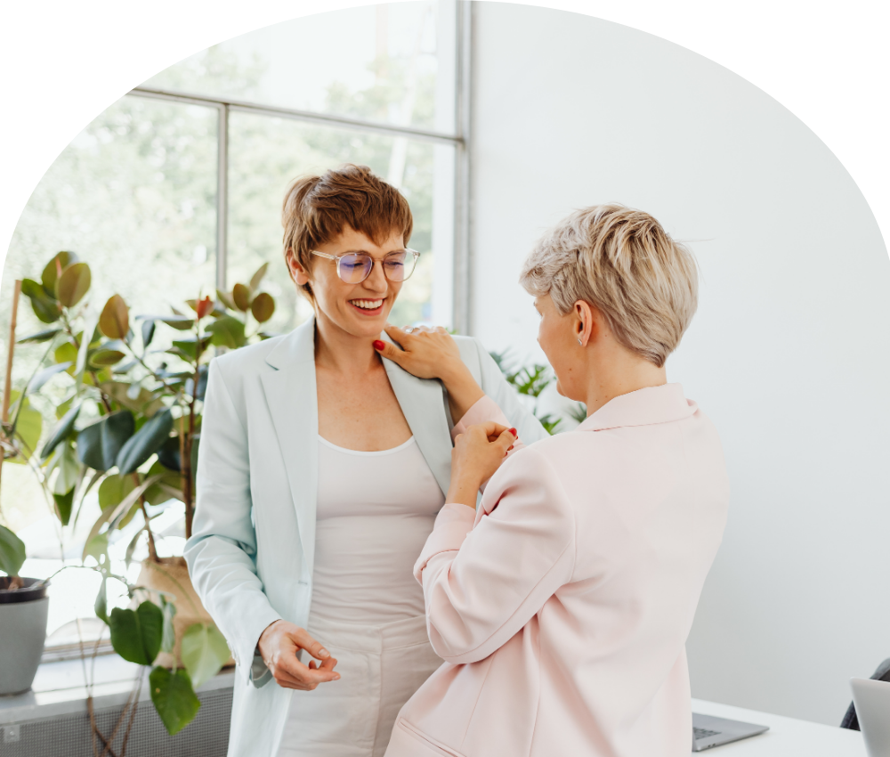 Two women in animated conversation — illustrating the forward-facing thought partnership at the heart of career coaching for mission-driven professionals navigating transitions and next steps.