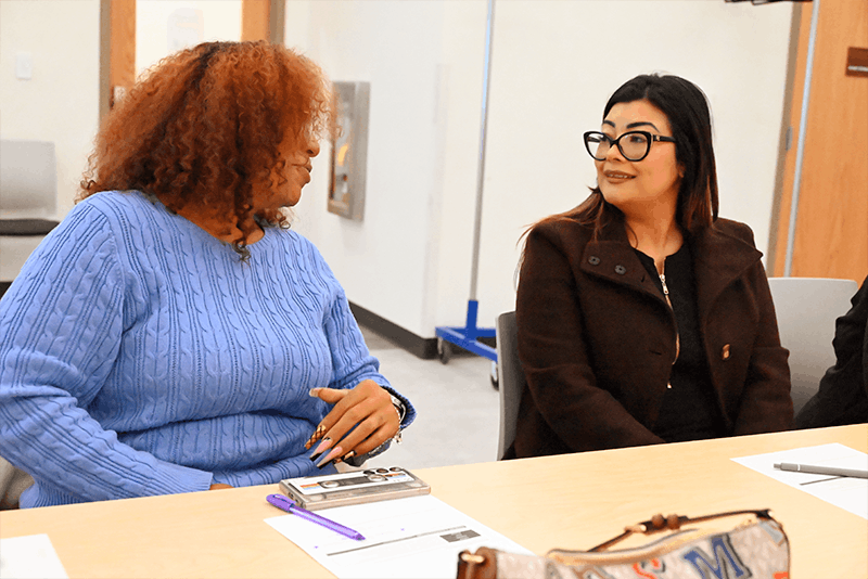 to smiling women talking to one another