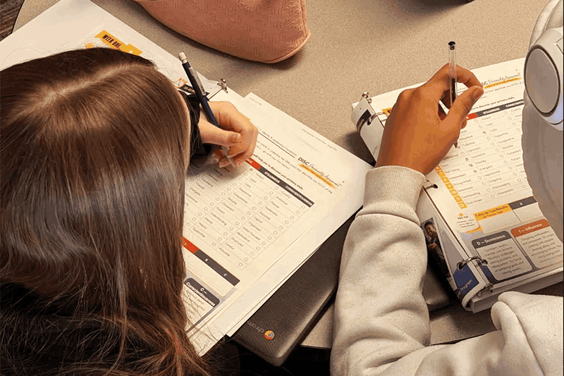 aerial shot of two students working on papers at a desk