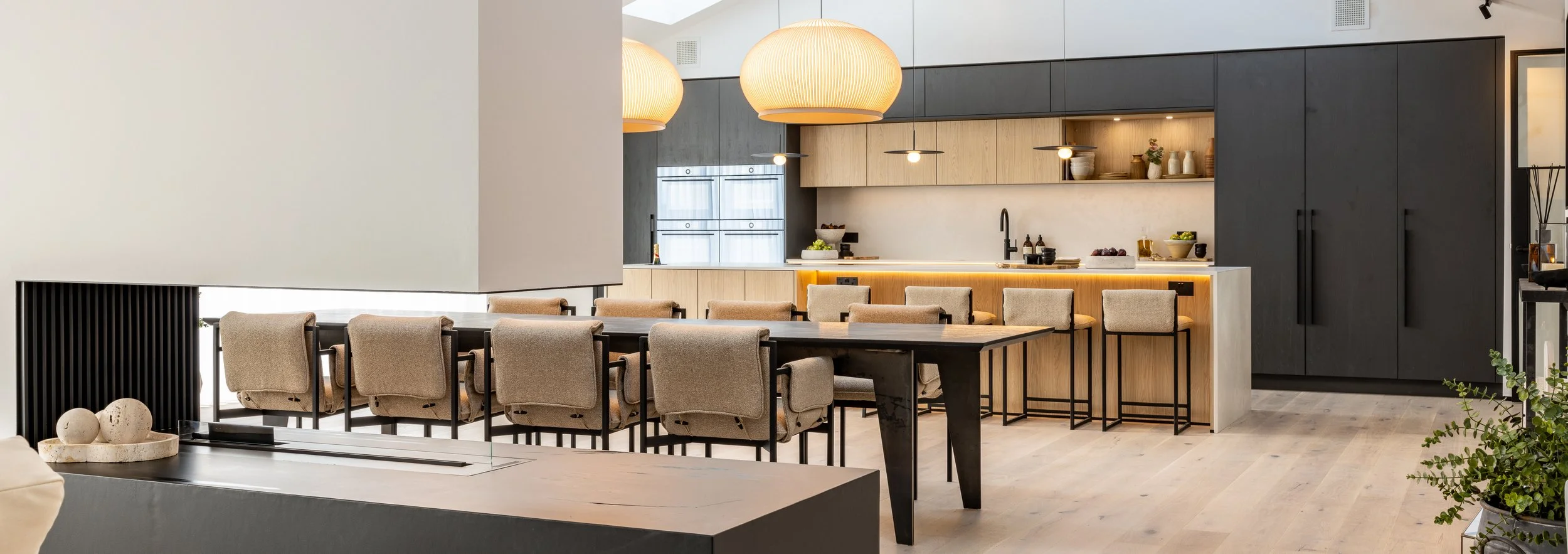Open-plan kitchen and dining interior at Hartdene Barns with timber cabinetry, dark joinery and pendant lighting.