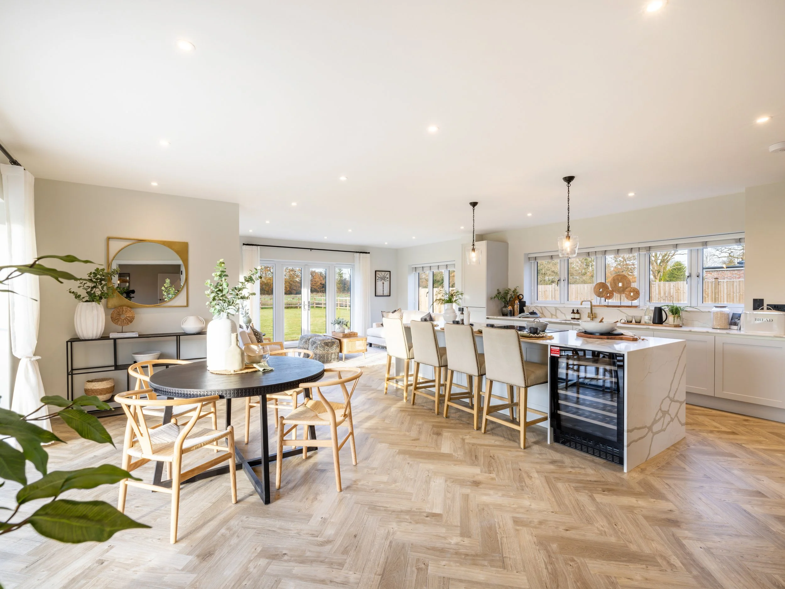 Bright kitchen at Oldencraig Mews with white cabinetry, a central island and natural light from the garden-facing windows.