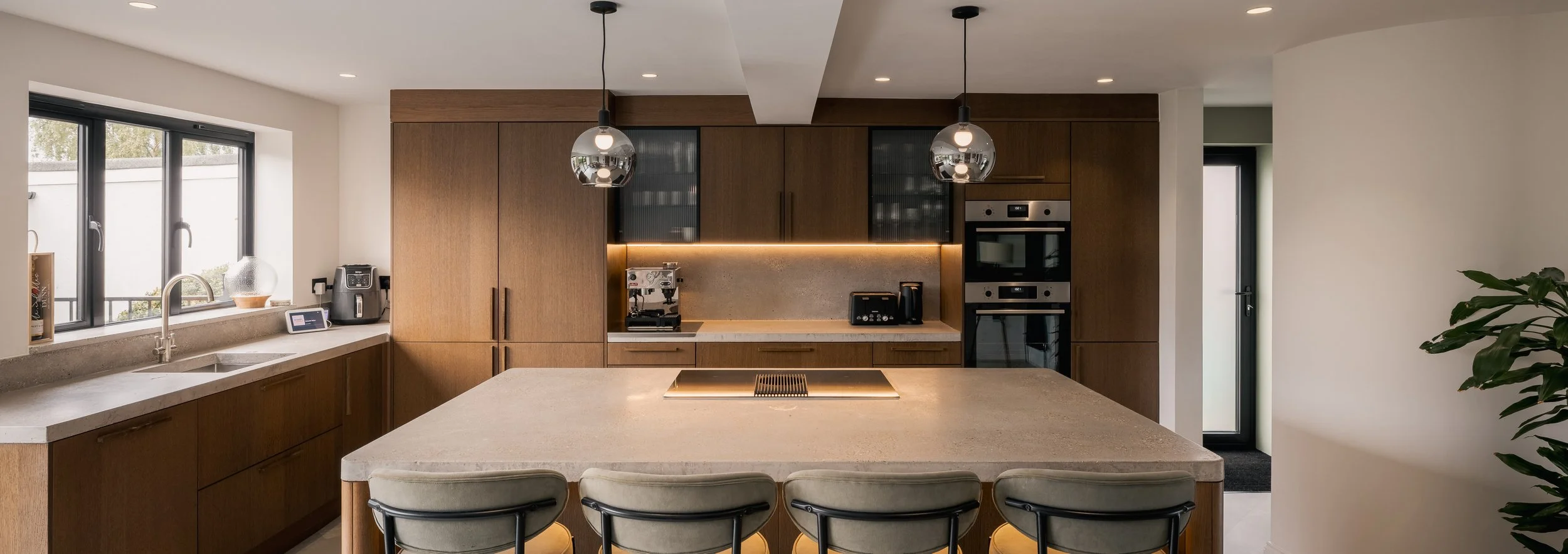 Kitchen at Elwood House with warm wood cabinetry, a central island and pendant lights.