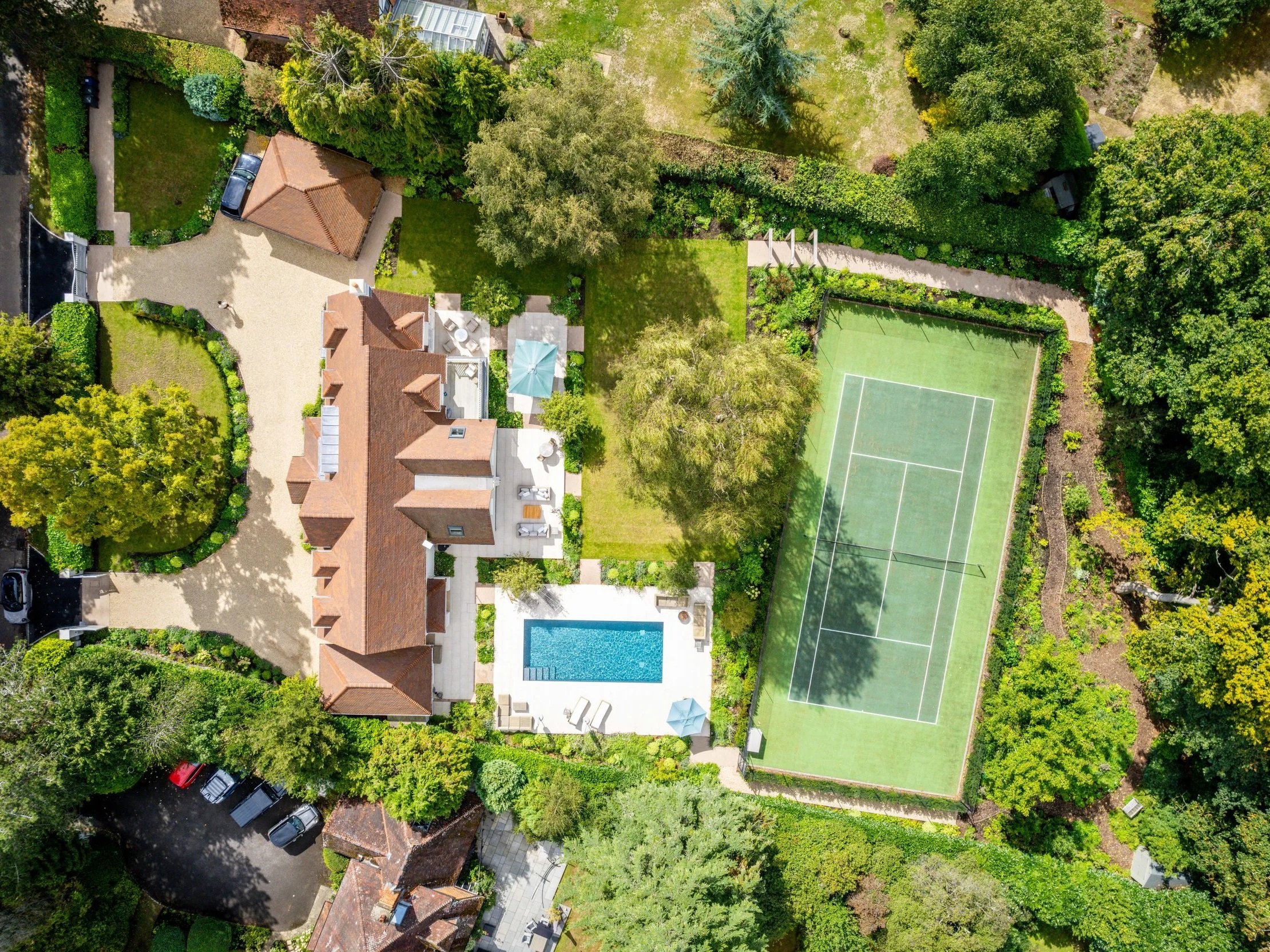 Aerial view of a country house, swimming pool, landscaped grounds and tennis court at Fairacres