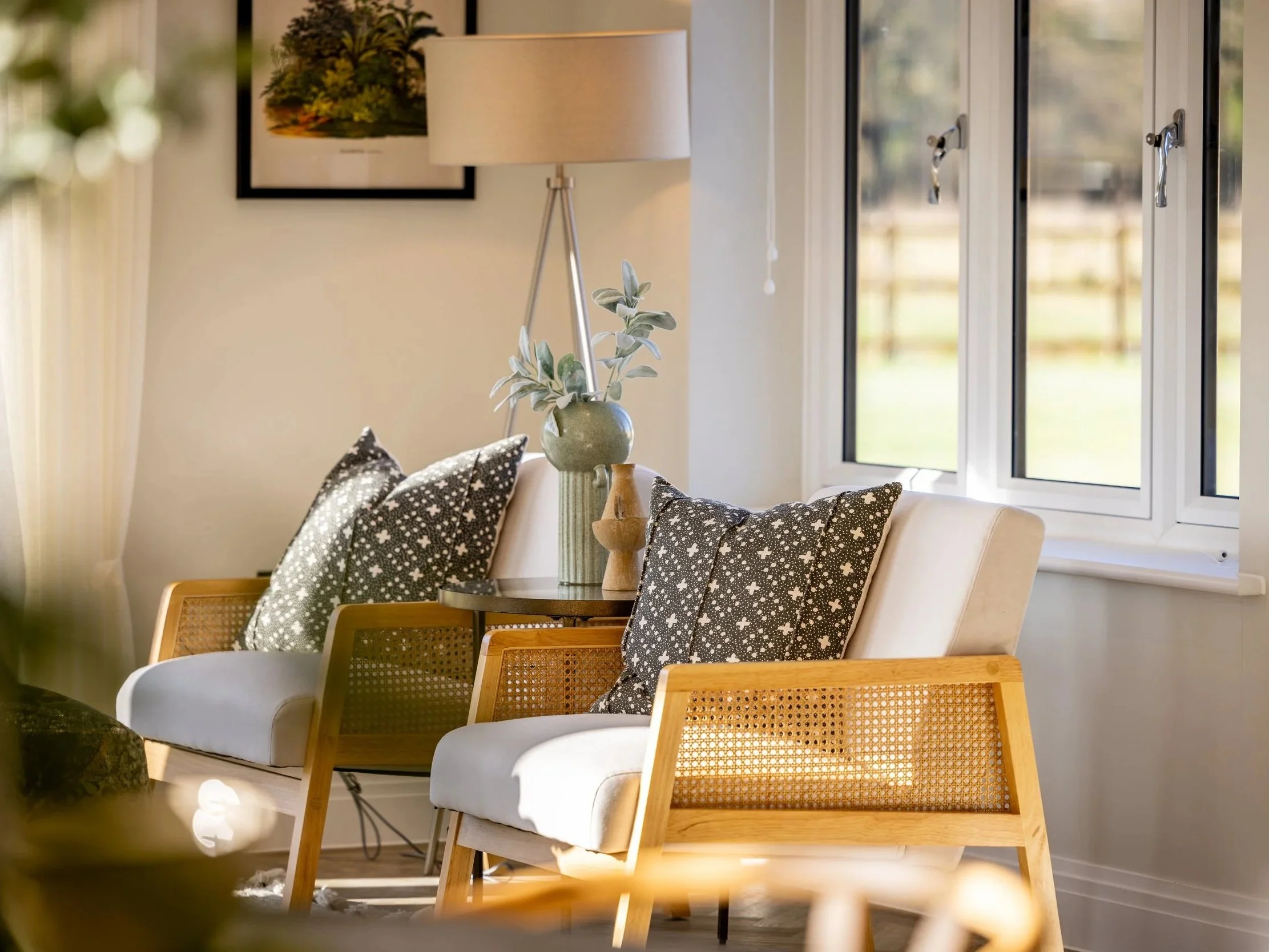 Seating area at Oldencraig Mews with upholstered chairs beside tall garden-facing windows.