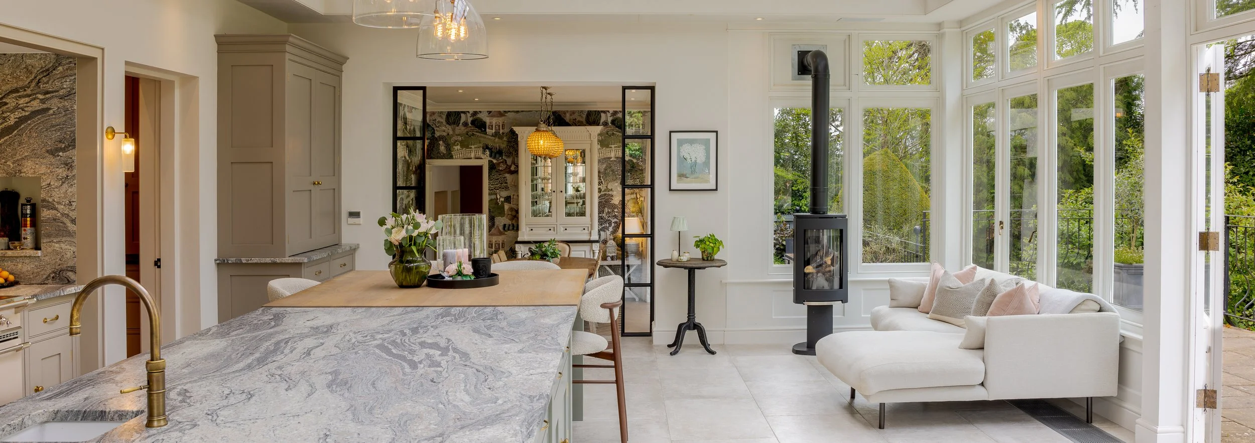 Open-plan kitchen and garden room at Albury Road with stone worktops, a wood-burning stove and views into the garden.