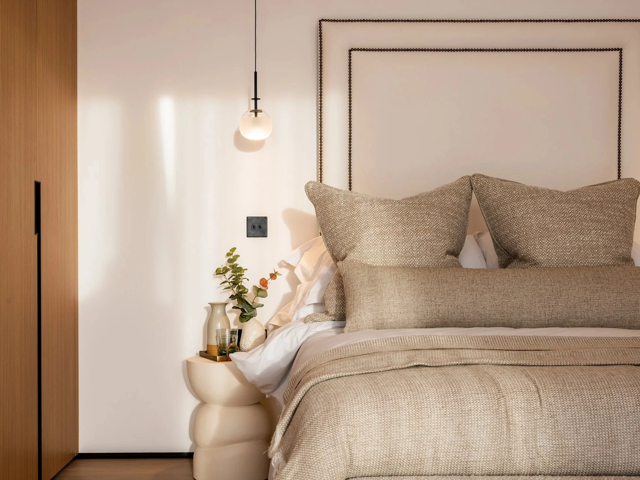 Bedroom at Hartdene Barns with a calm neutral palette, upholstered headboard and soft natural light.