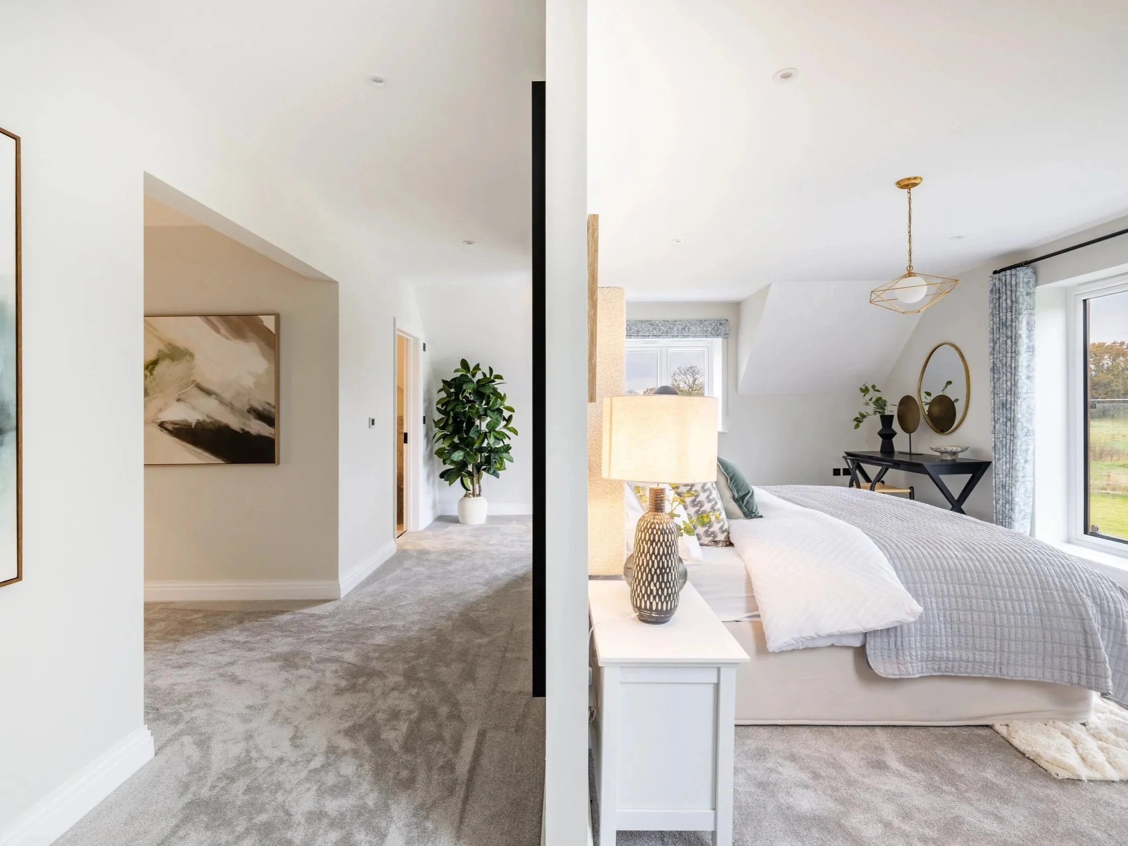 Bright bedroom at Oldencraig Mews seen through an open doorway, with neutral bedding and pale walls.