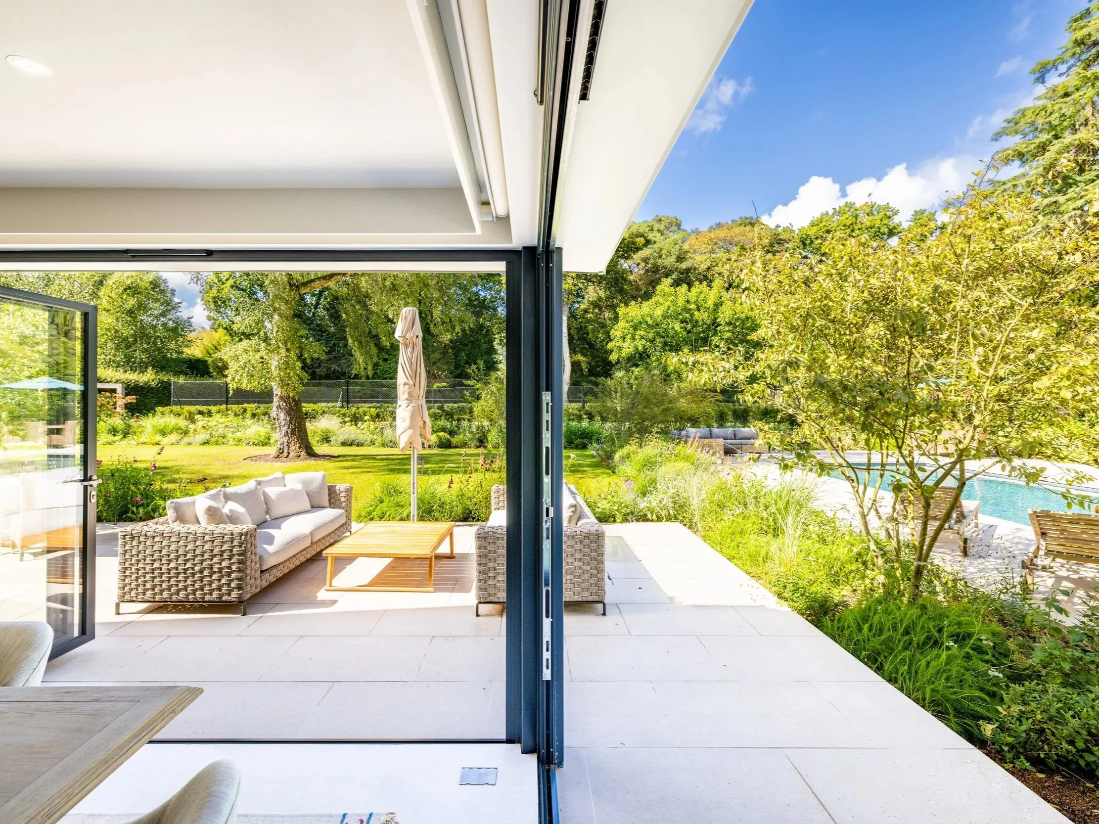 Open folding doors connect Mayfair House’s interior with a terrace, swimming pool and landscaped garden.