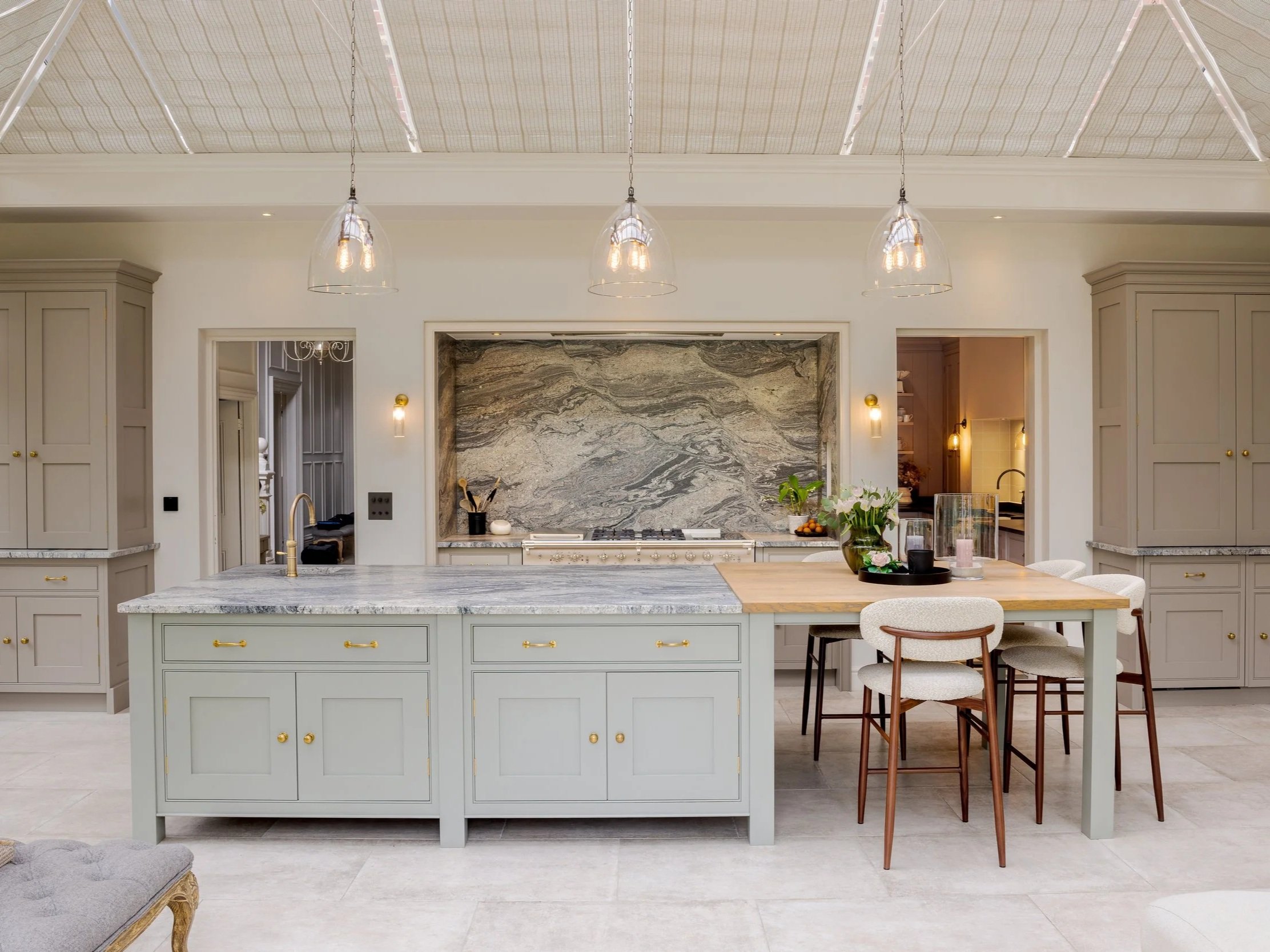 Kitchen at Albury Road with painted cabinetry, a stone island and a dramatic natural-stone splashback.