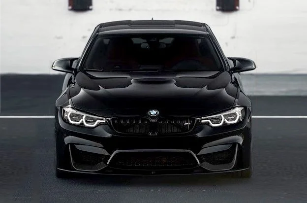 Black BMW car parked on the street facing forward.