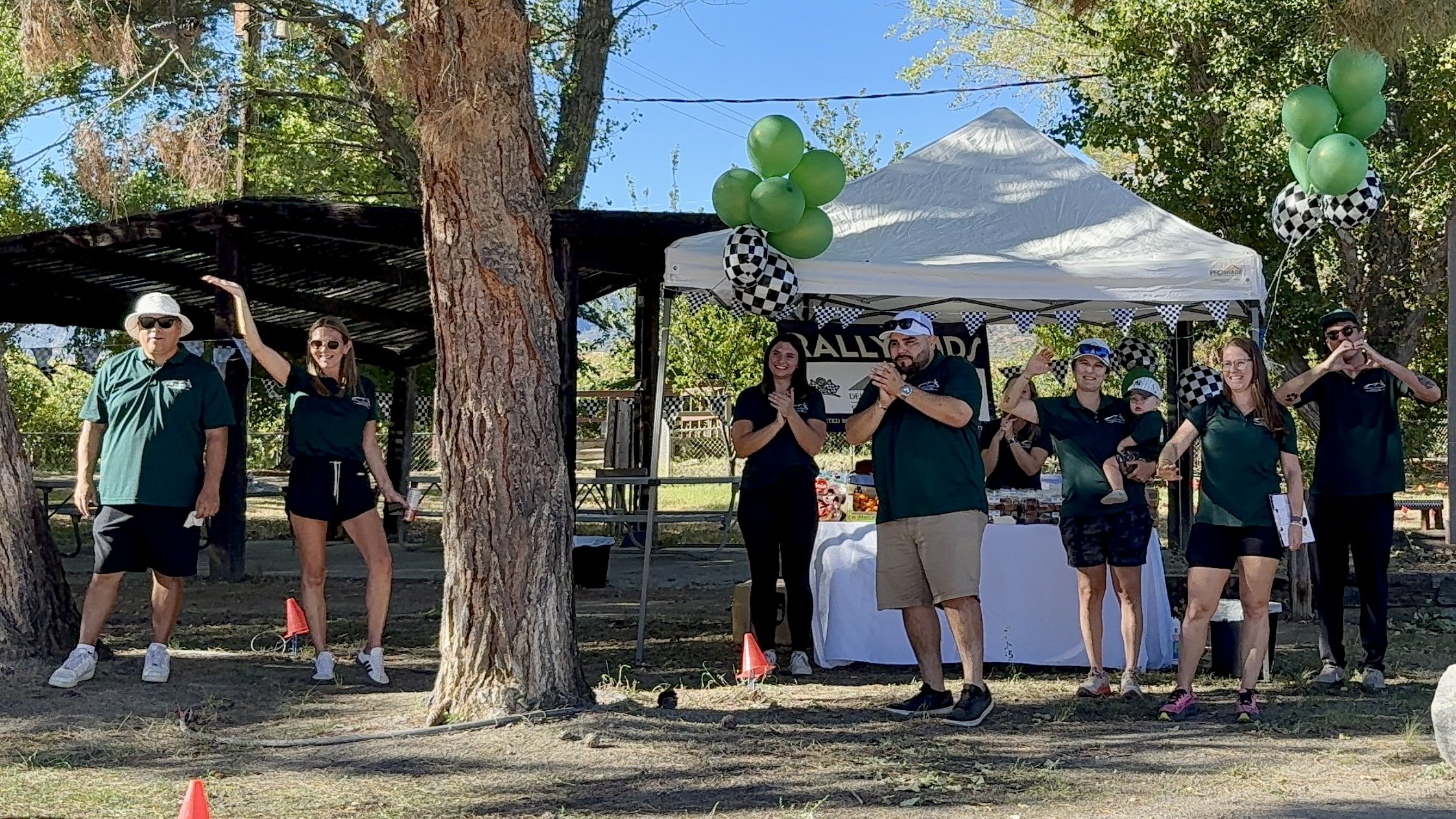people-in-green-shirts-clapping-under-white-tent--c1710d50.jpeg