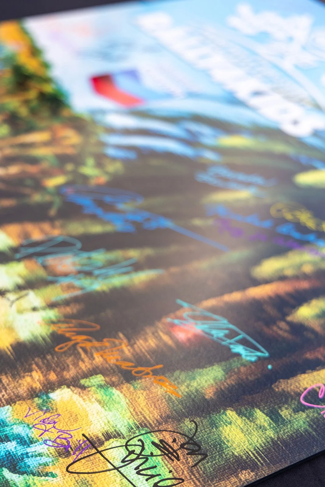 Close-up of a colorful, abstract background with handwritten signatures and text in various vibrant colors.