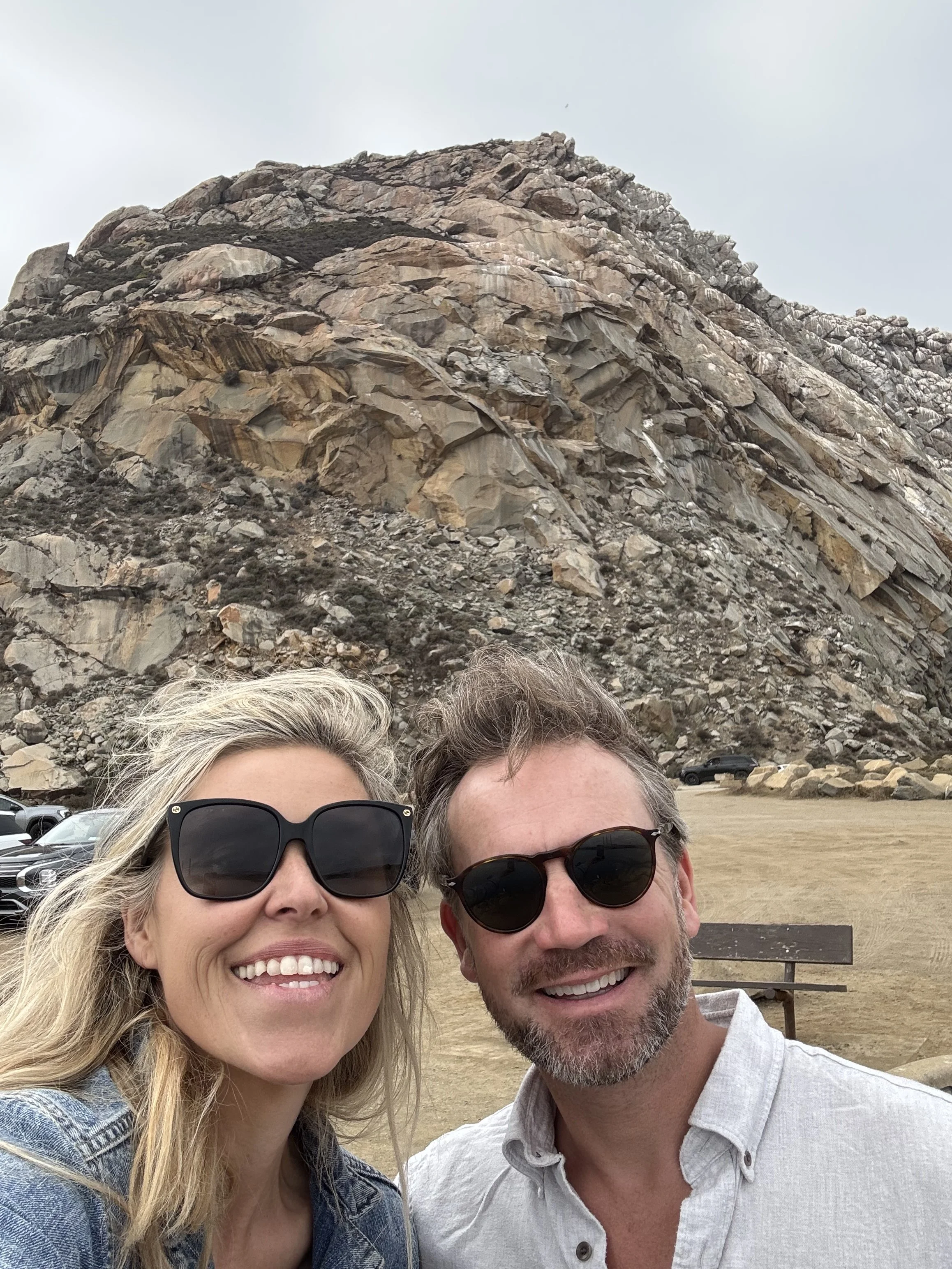 smiling-couple-wearing-sunglasses-in-front-of-a-rocky-hill--bbbac39d.jpeg